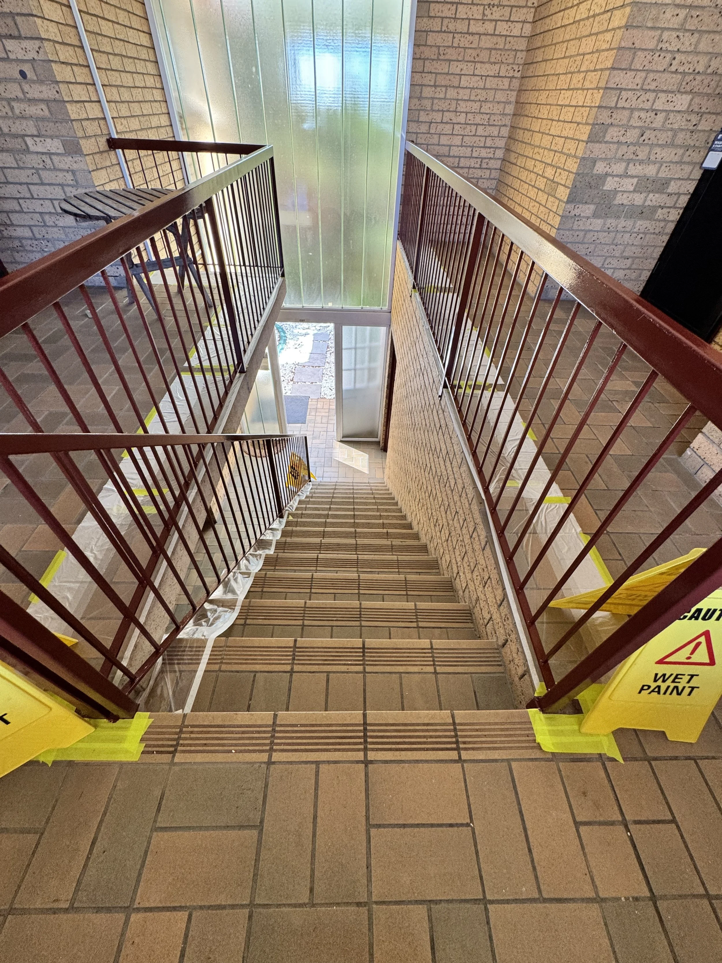 Painted body corporate stairwell with safety signs during painting works