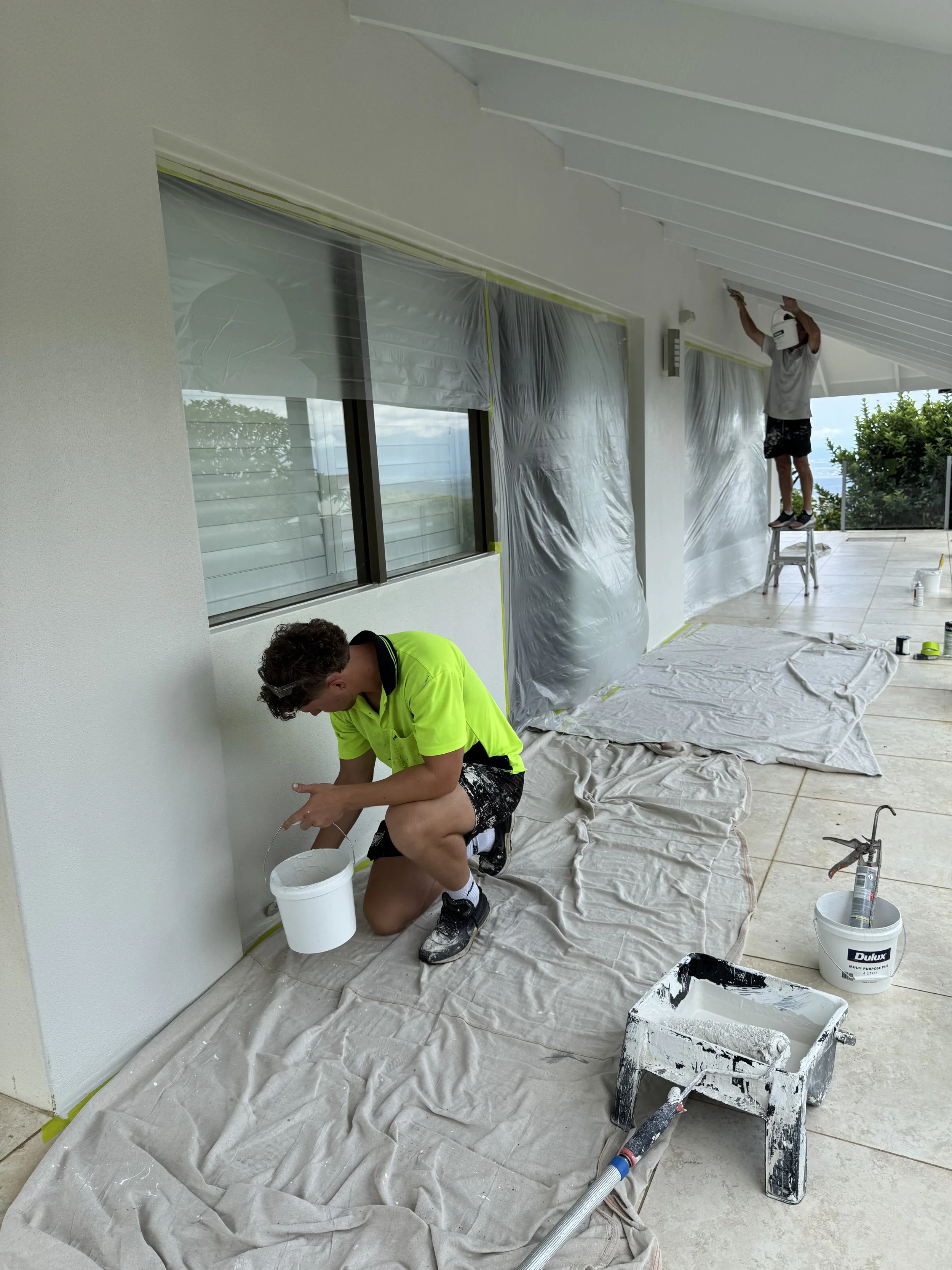 CAC Coatings painters applying exterior paint with surrounding surfaces protected.