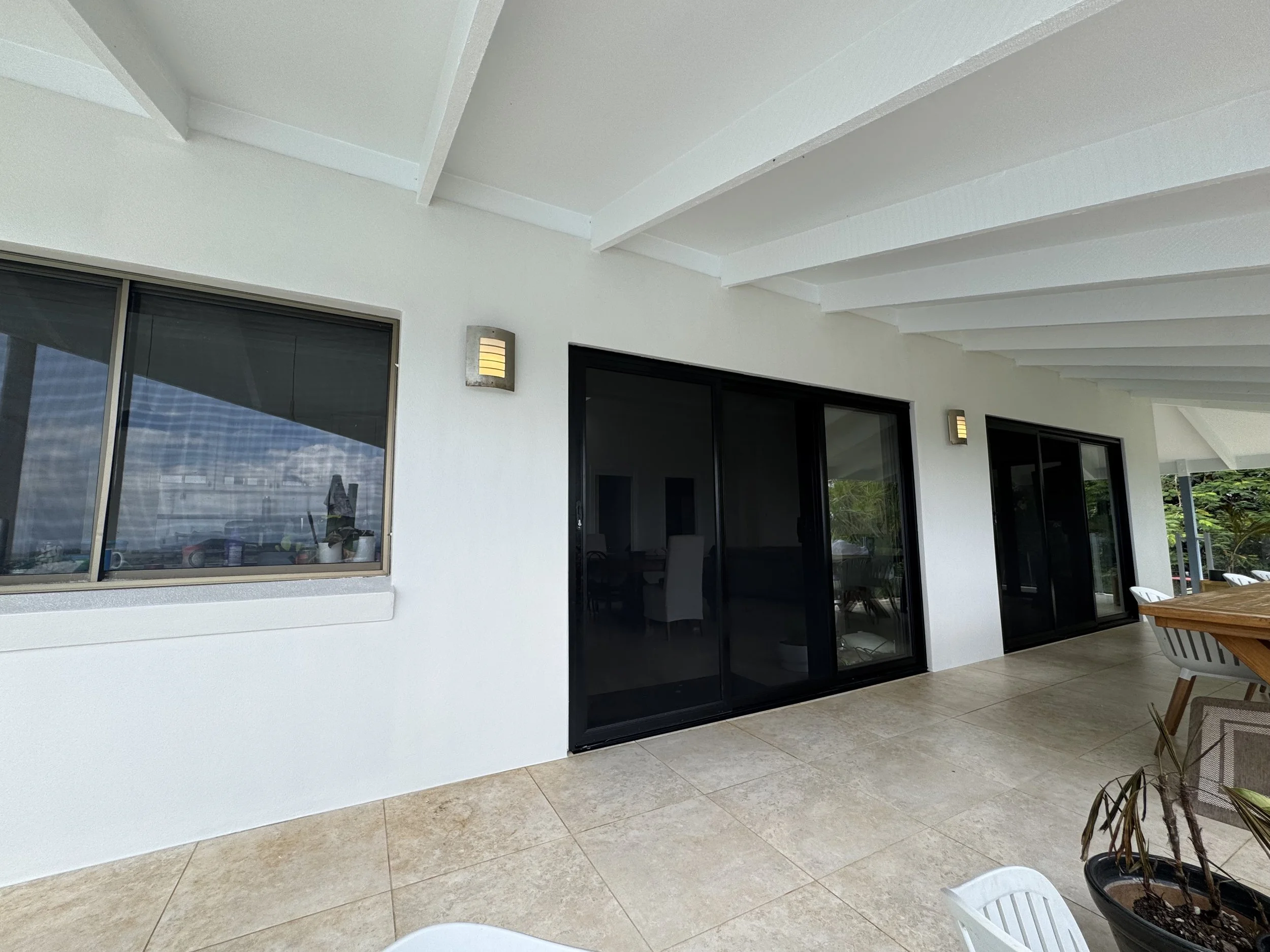 Freshly painted covered patio with white walls and ceiling by CAC Coatings.