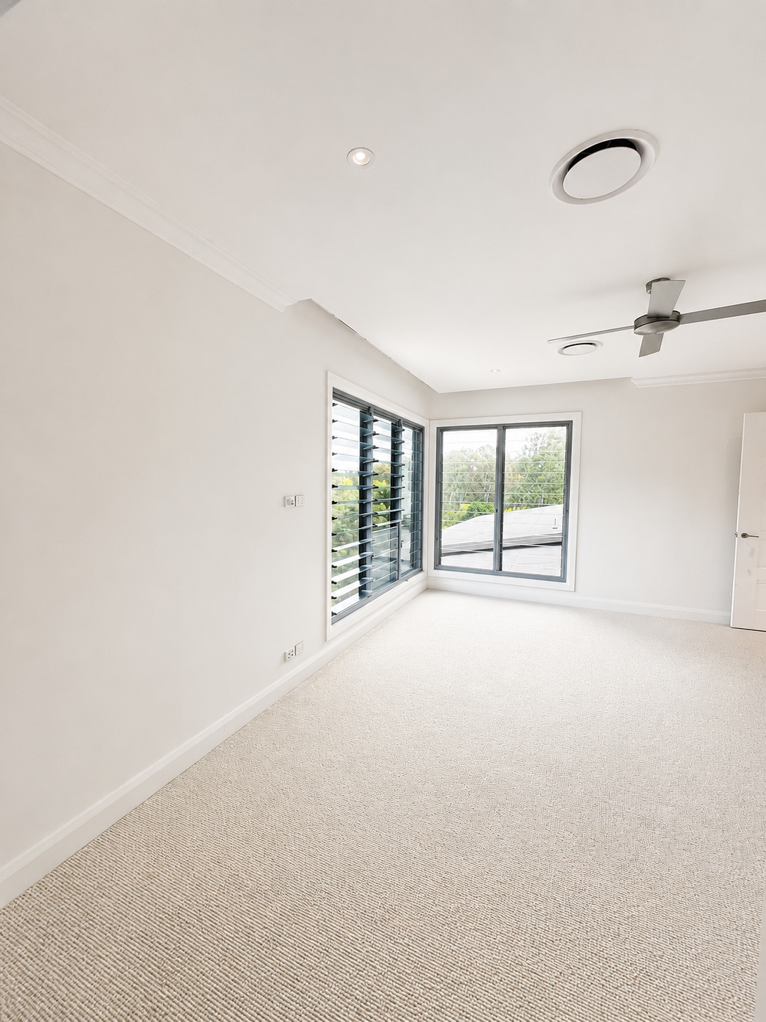 Freshly painted residential bedroom with white walls and trim