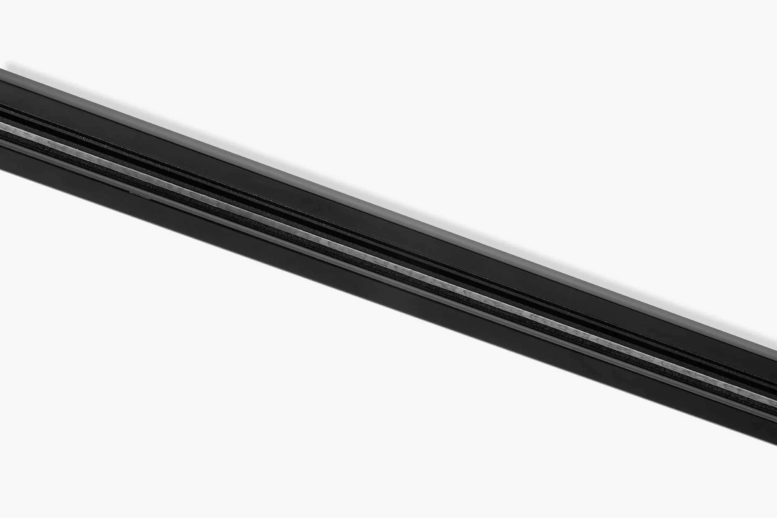Close-up of a black light track by LIK Lighting, with metal accents on a white background.