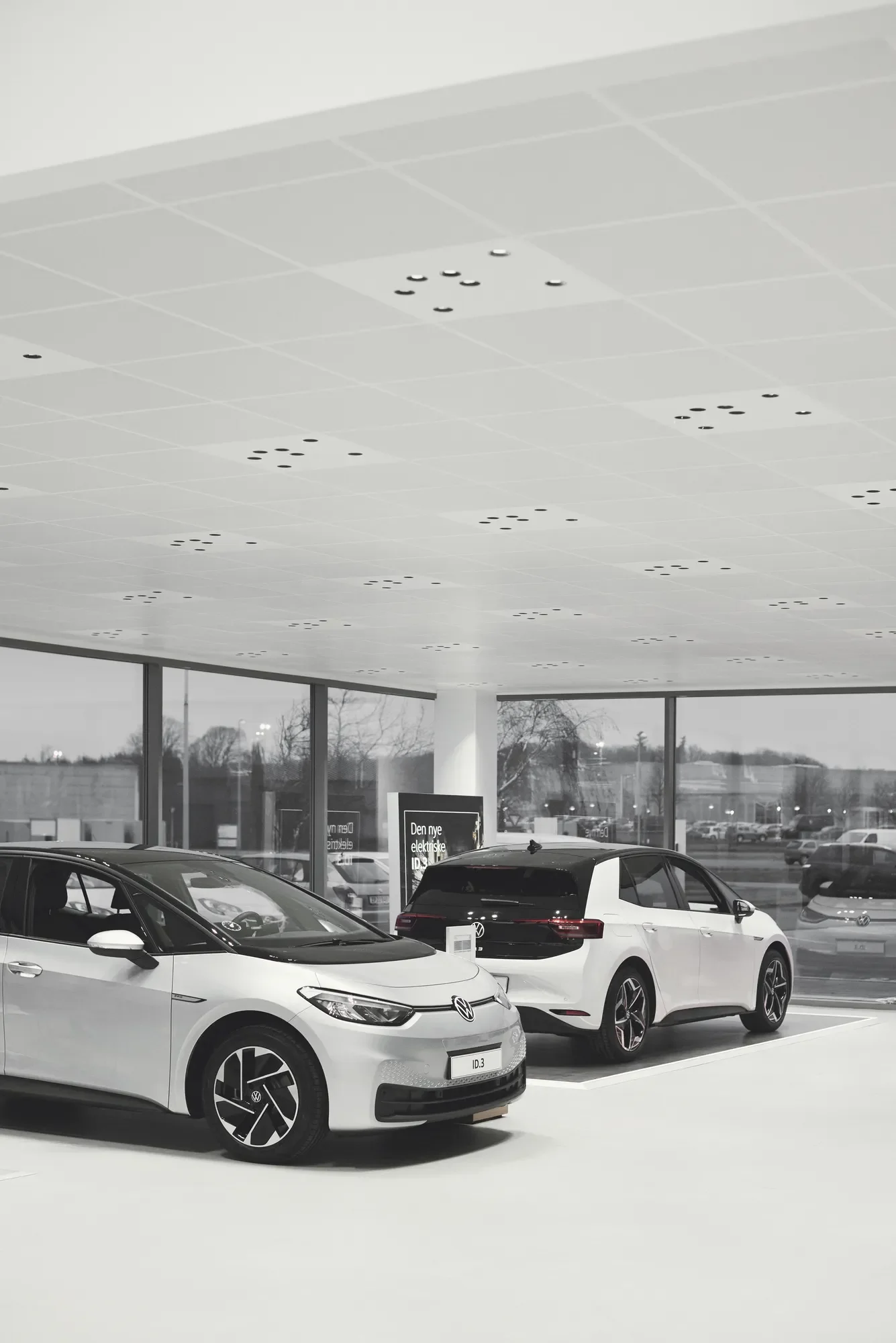 Volkswagen ID.3 electric cars displayed in a bright dealership showroom with lighting design by by LIK Lighting