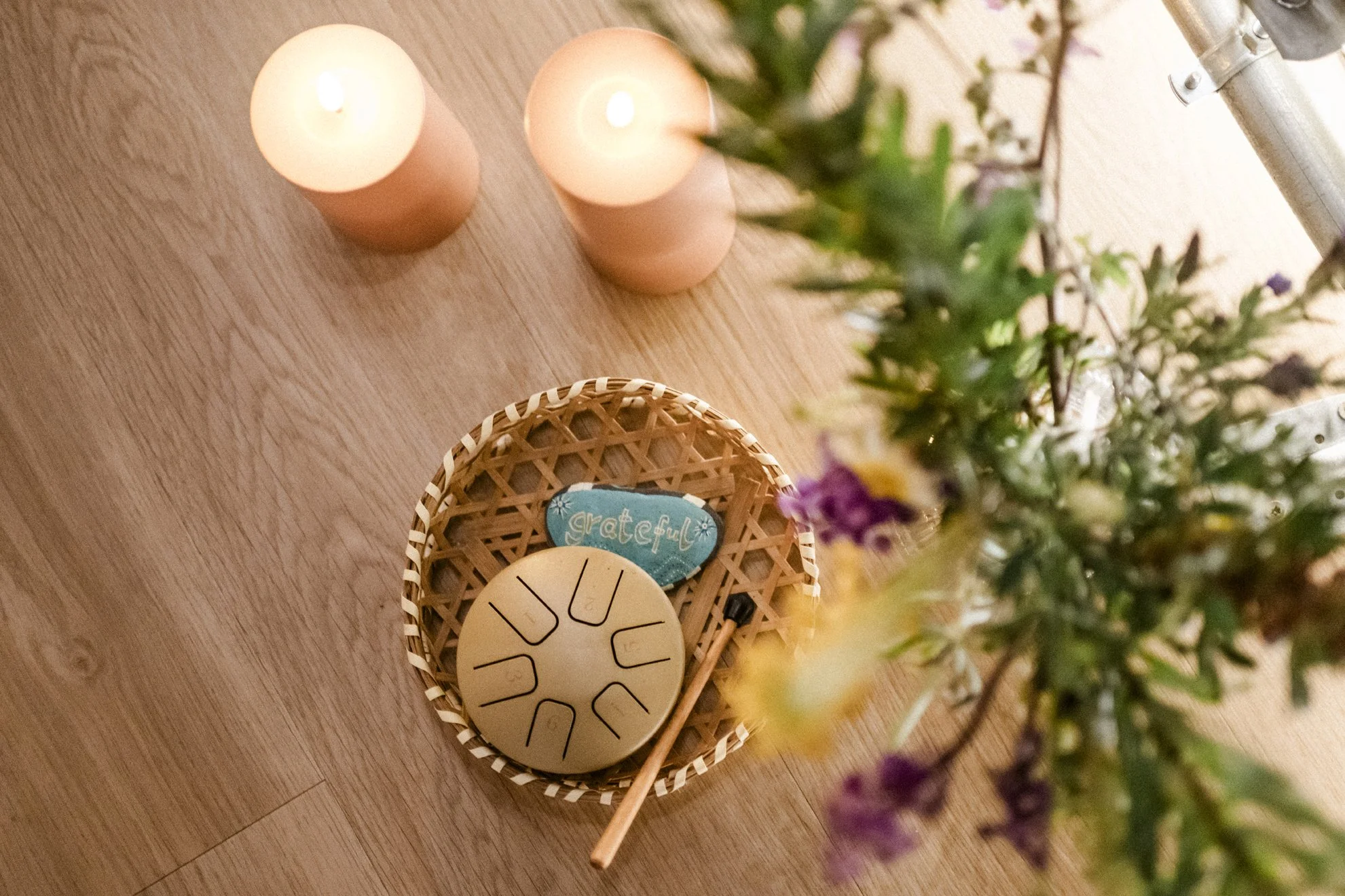 Blick auf zwei Kerzen, einen Blumenstrauß und eine schöne Dekoration auf einem Holztisch.