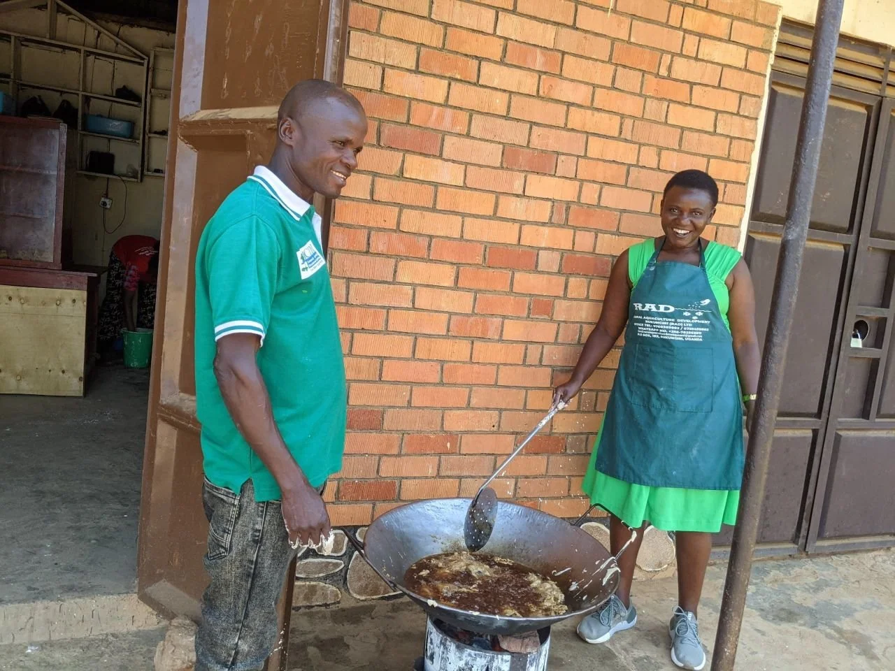 RAD Uganda sales team at a local market frying tilapia