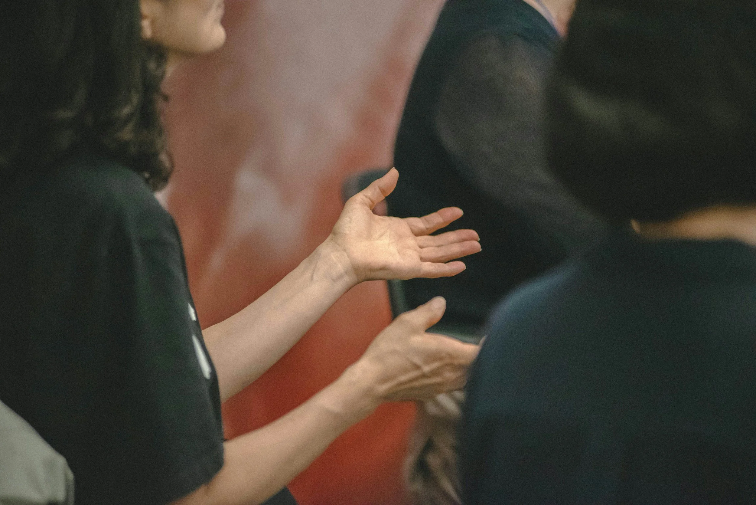 Persone con le mani in movimento sedute in una sala
