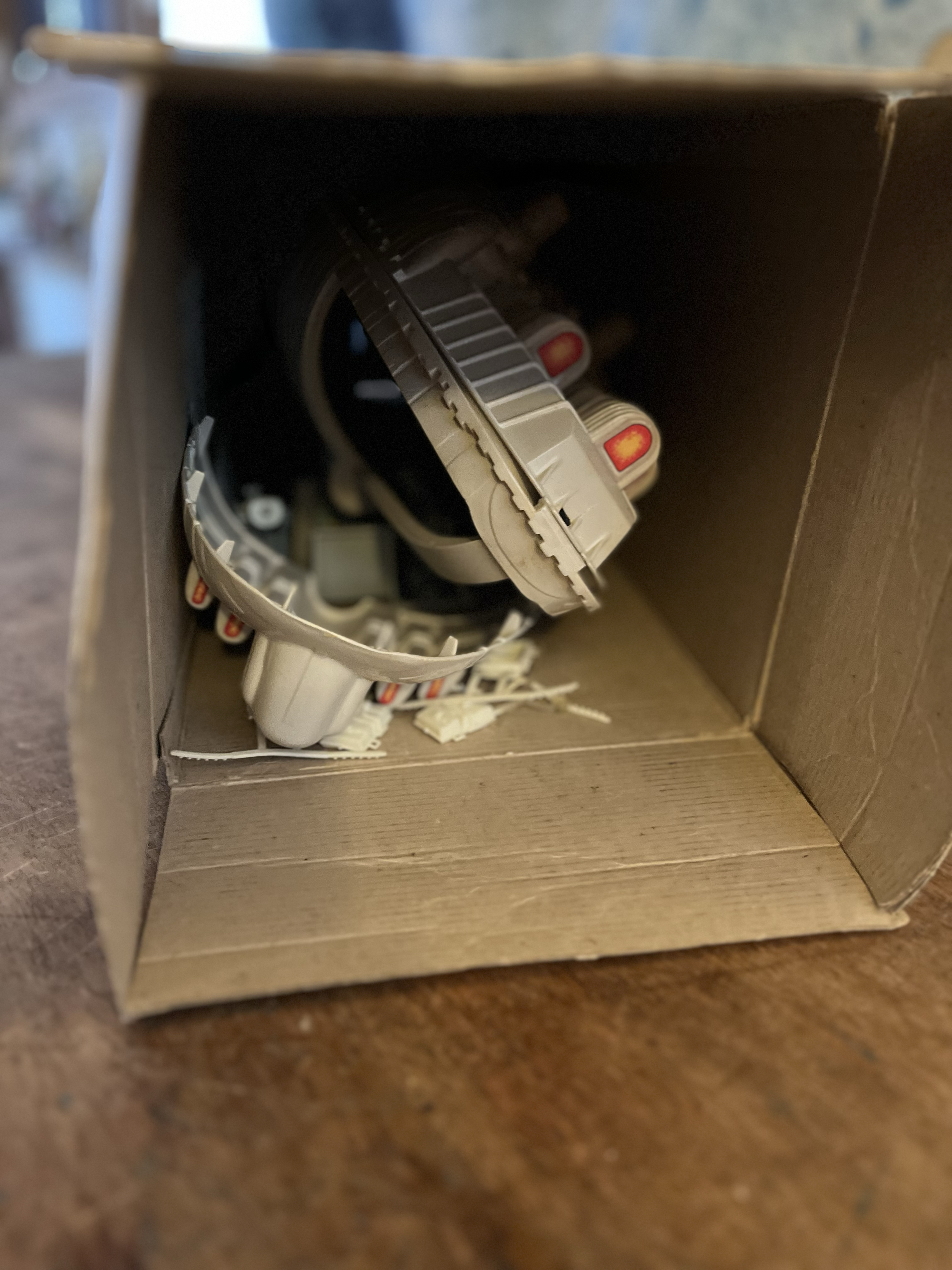 A cardboard box containing several gray and red Nintendo Switch Joy-Con controllers, viewed from inside the box.