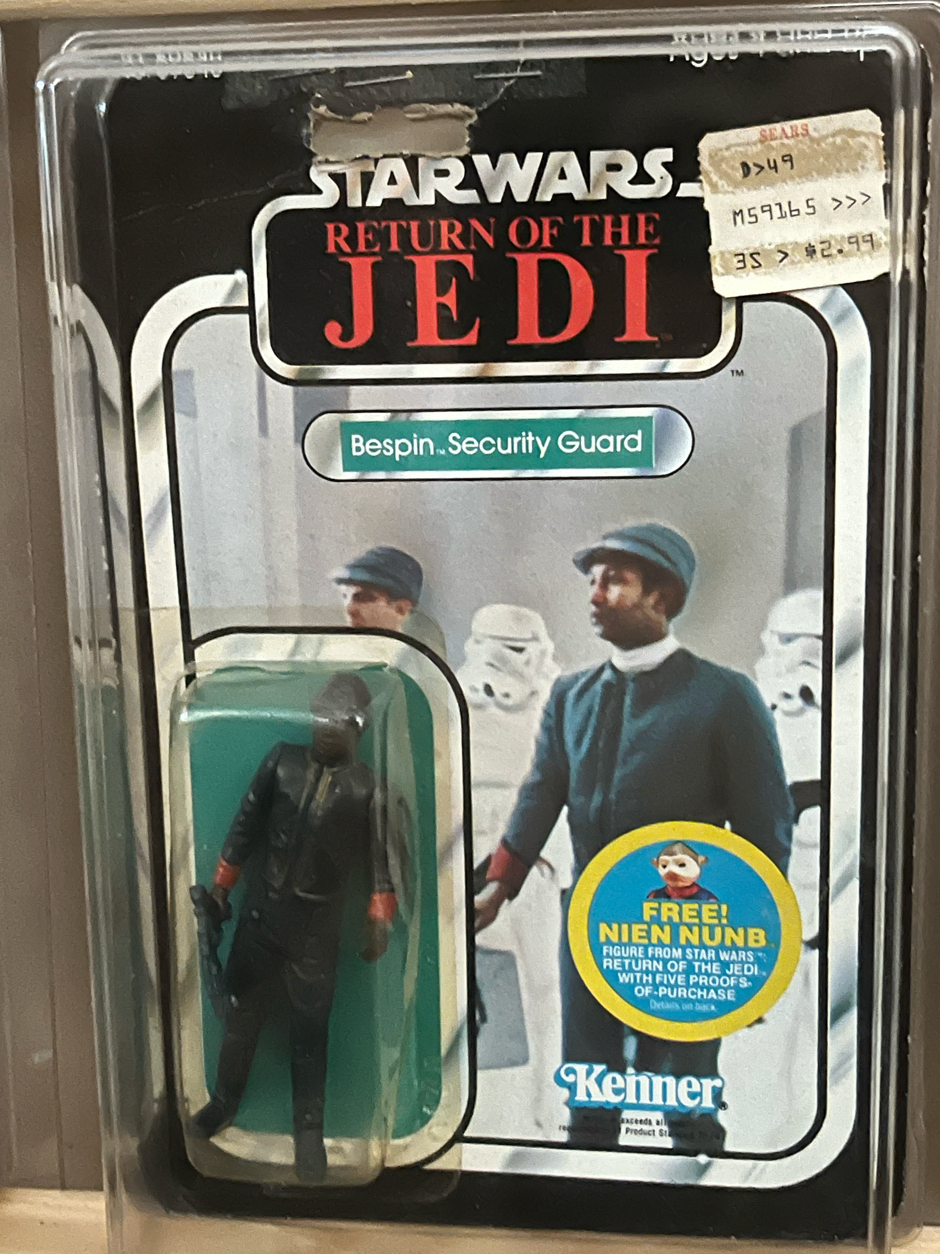 A Disney Star Wars-themed collectible figure of Poe Dameron in pilot uniform, enclosed in a clear plastic case with Star Wars branding and a yellow blue sticker that reads 'Fuego! Fett' from a Star Wars movie.