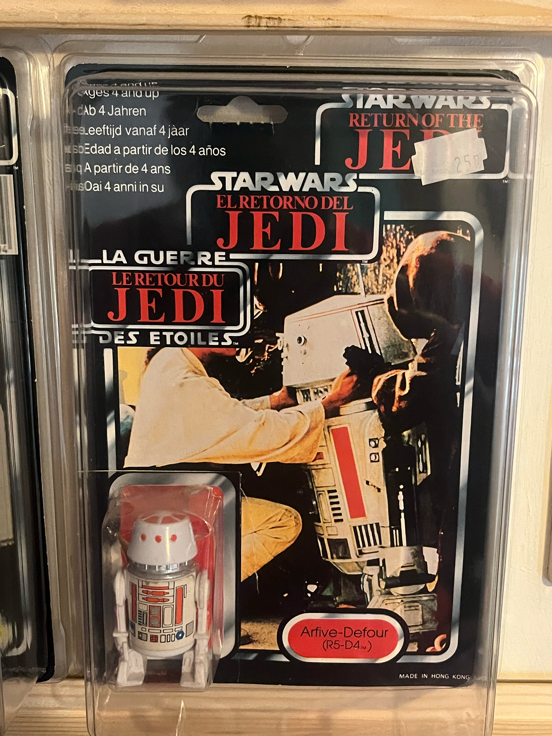 A clear plastic case containing a Star Wars-themed LEGO set box and LEGO microfigures, with a partially visible instruction manual.