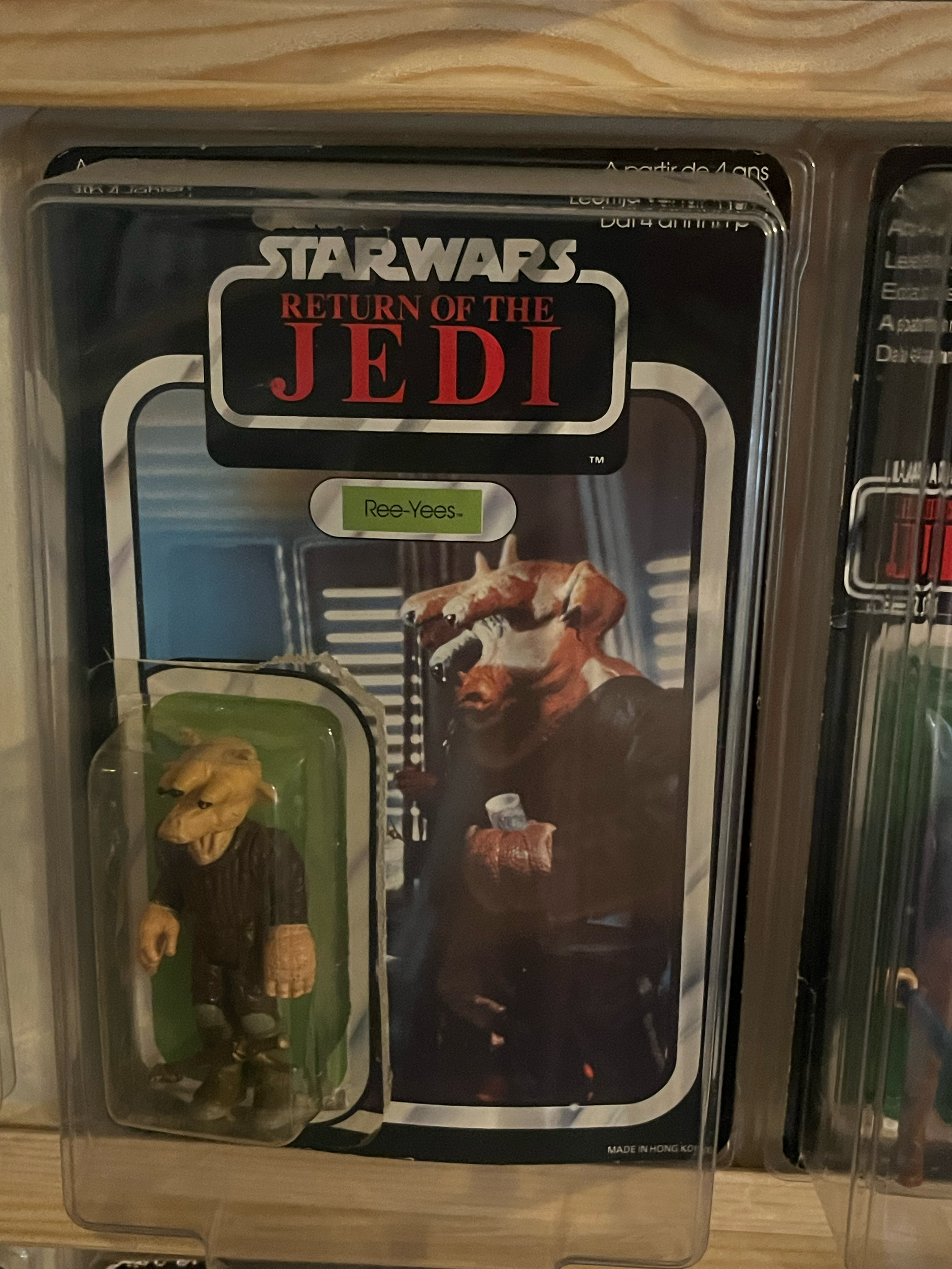 A storage container filled with various action figures and collectibles from the 'Star Wars' universe, including figures of Anakin Skywalker and other characters, with a 'Star Wars: The Empire Strikes Back' label.