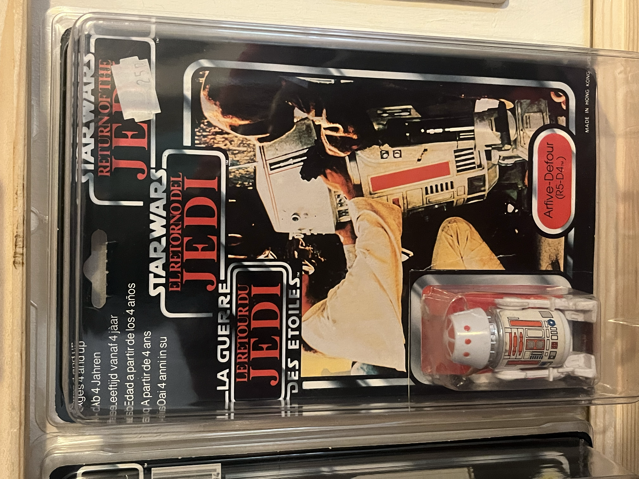 A clear plastic case containing a Star Wars-themed LEGO set box and LEGO microfigures, with a partially visible instruction manual.