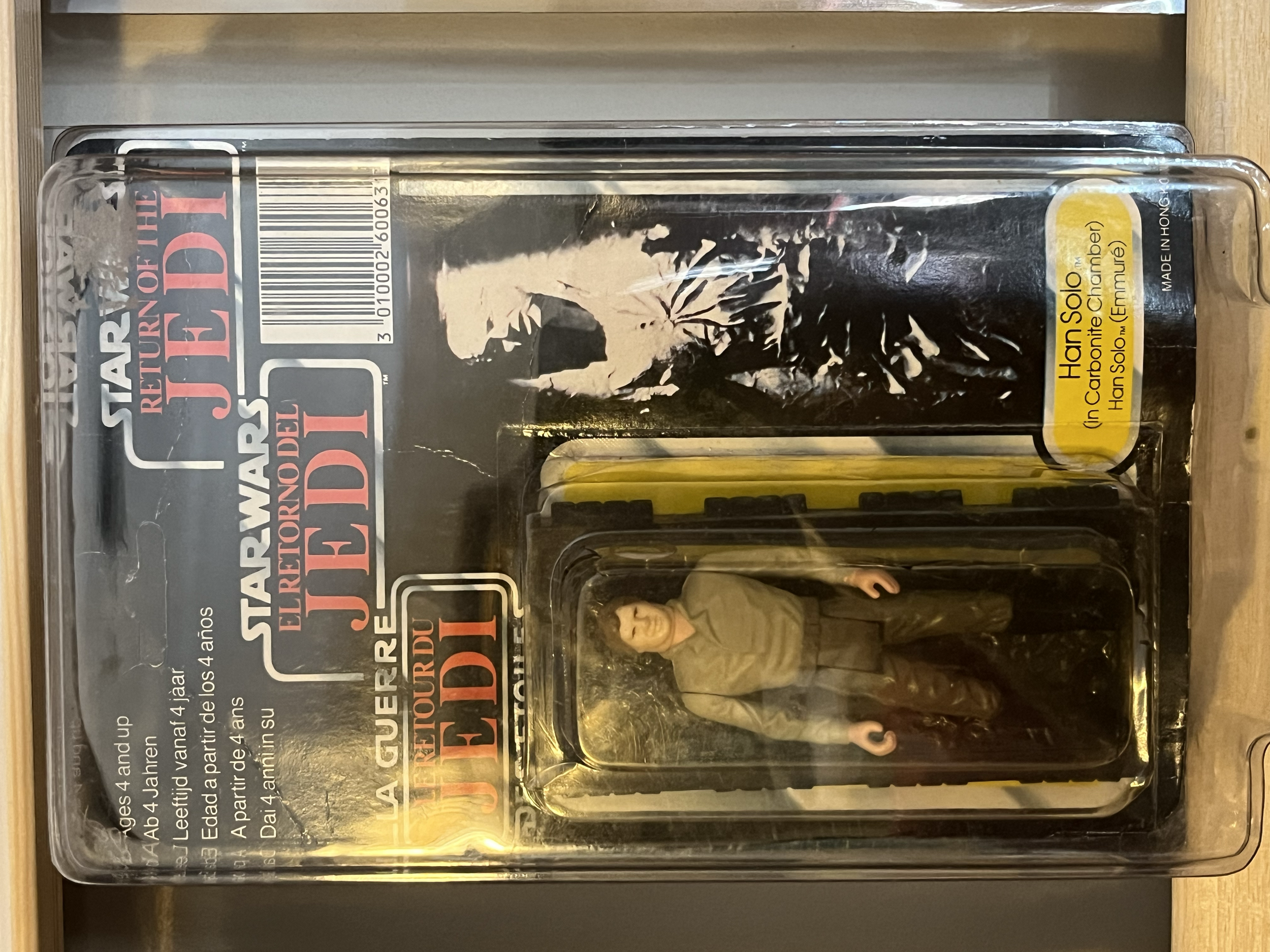 A collectible action figure of Han Solo from Star Wars in original packaging, with a dark background and yellow label.
