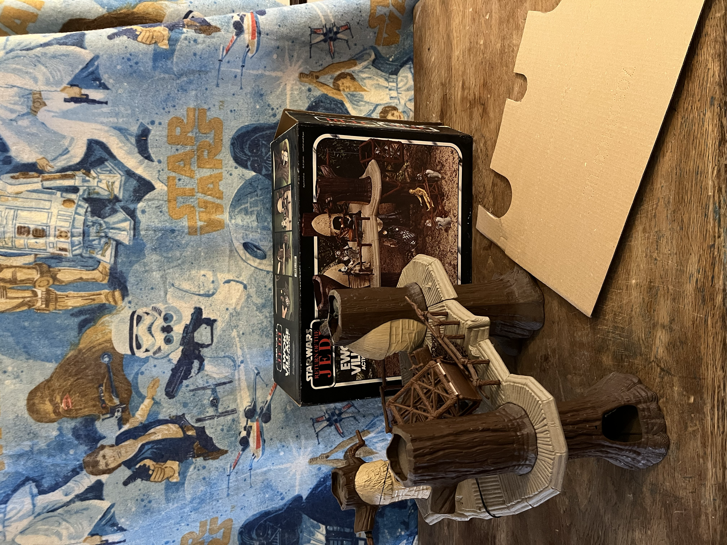 Star Wars themed puzzle box with miniature wooden chair models on a wooden table, with a Star Wars poster in the background.