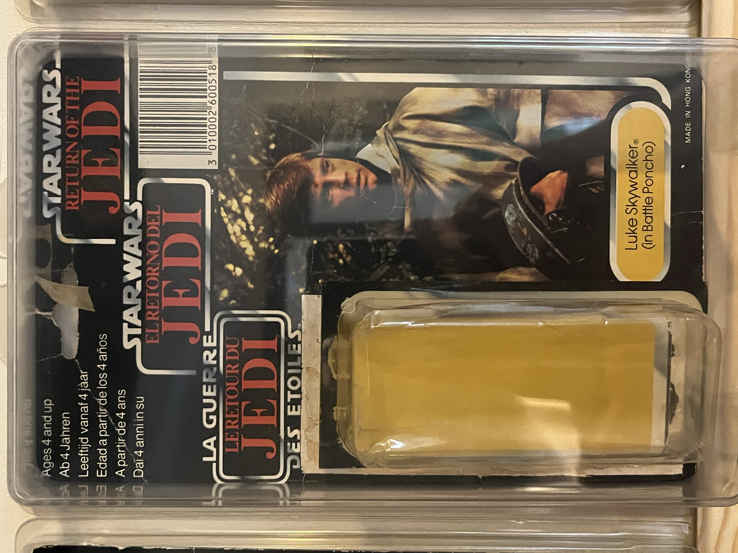 Plastic case containing yellowish liquid and a card with text and an image of a person.