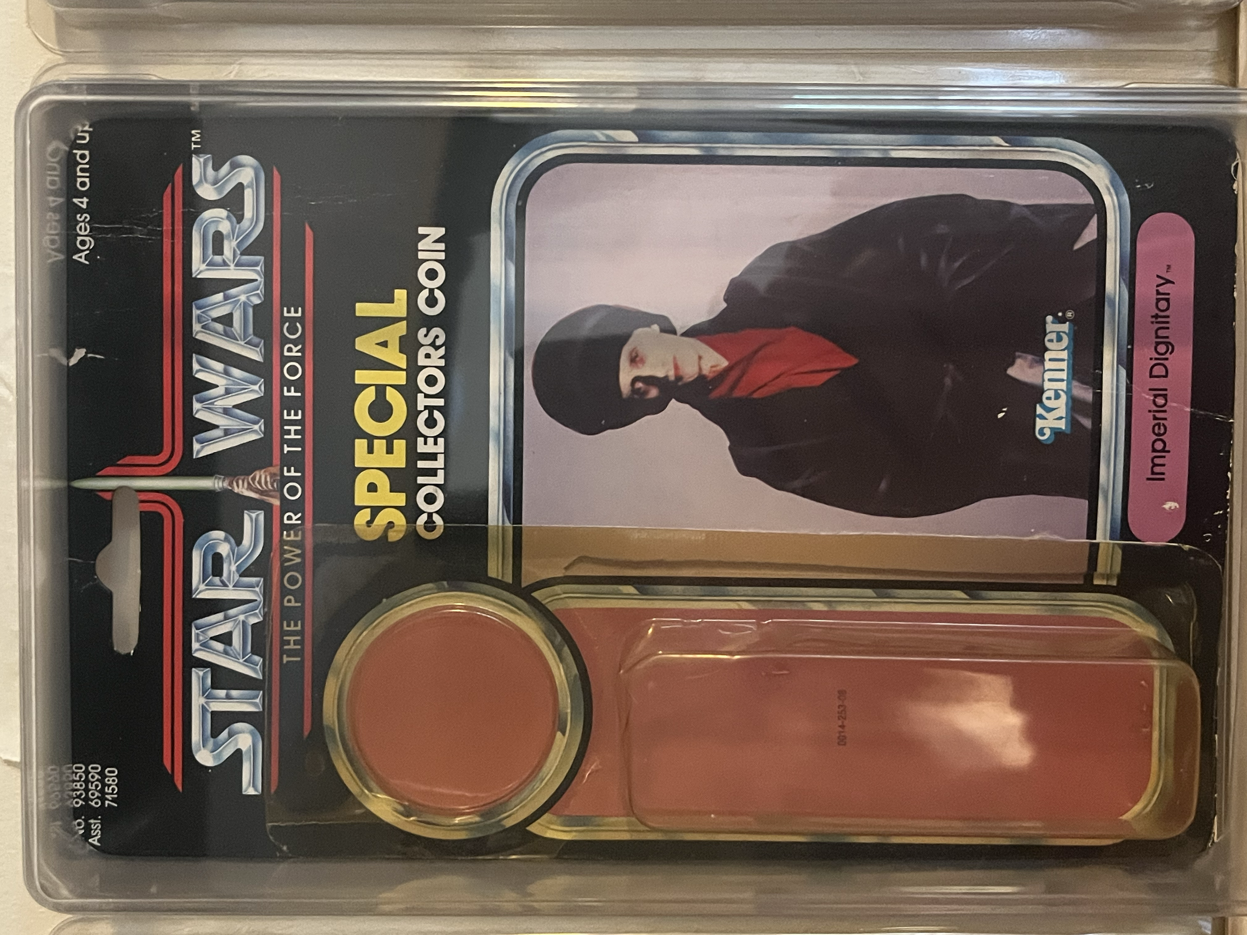 A collectible toy set featuring a character from Stone Cold Steve Austin with a black jacket, red shirt, black hat, and sunglasses, in original packaging with a black background. Contains round colored objects or tokens.