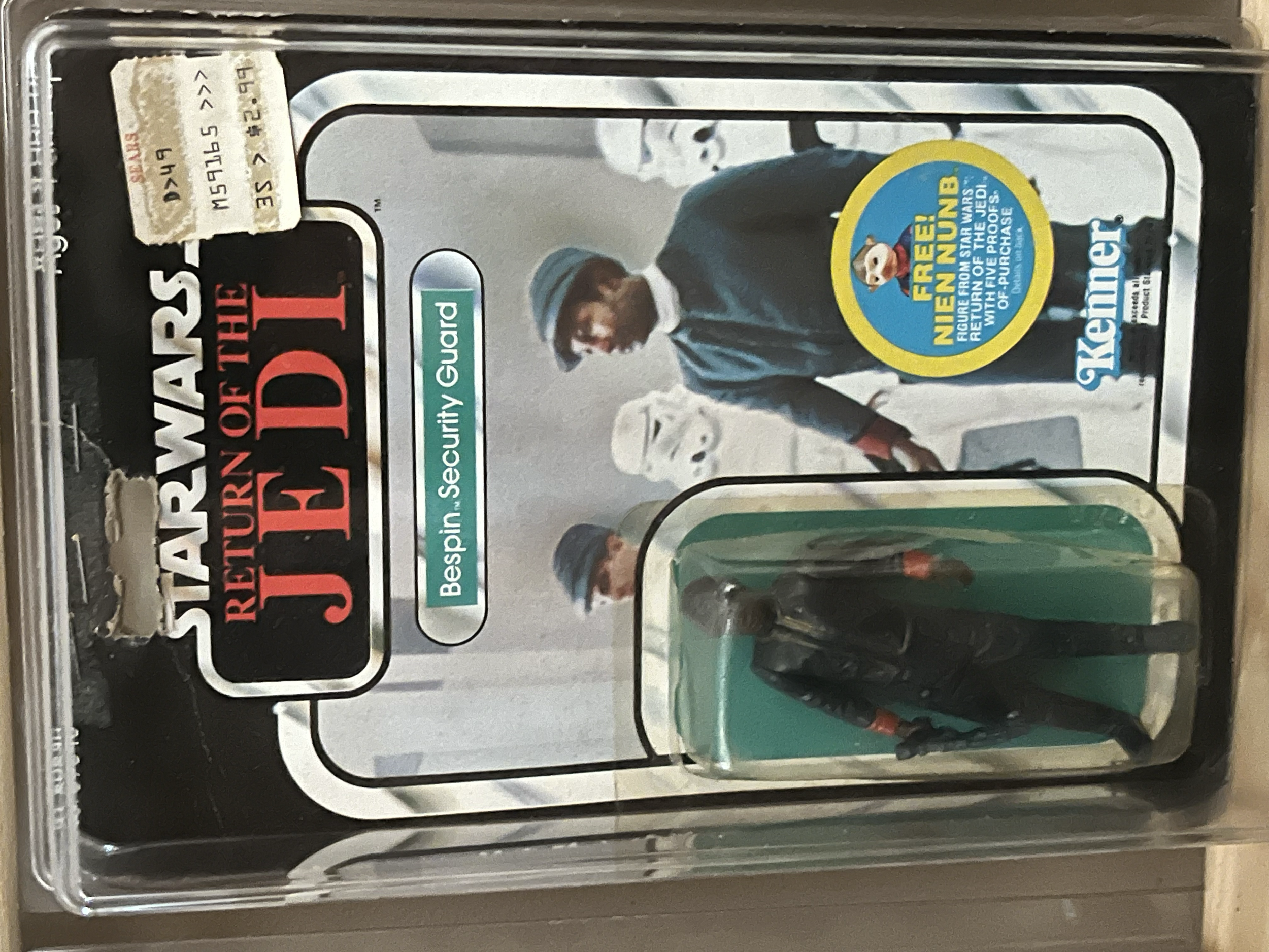 A Disney Star Wars-themed collectible figure of Poe Dameron in pilot uniform, enclosed in a clear plastic case with Star Wars branding and a yellow blue sticker that reads 'Fuego! Fett' from a Star Wars movie.