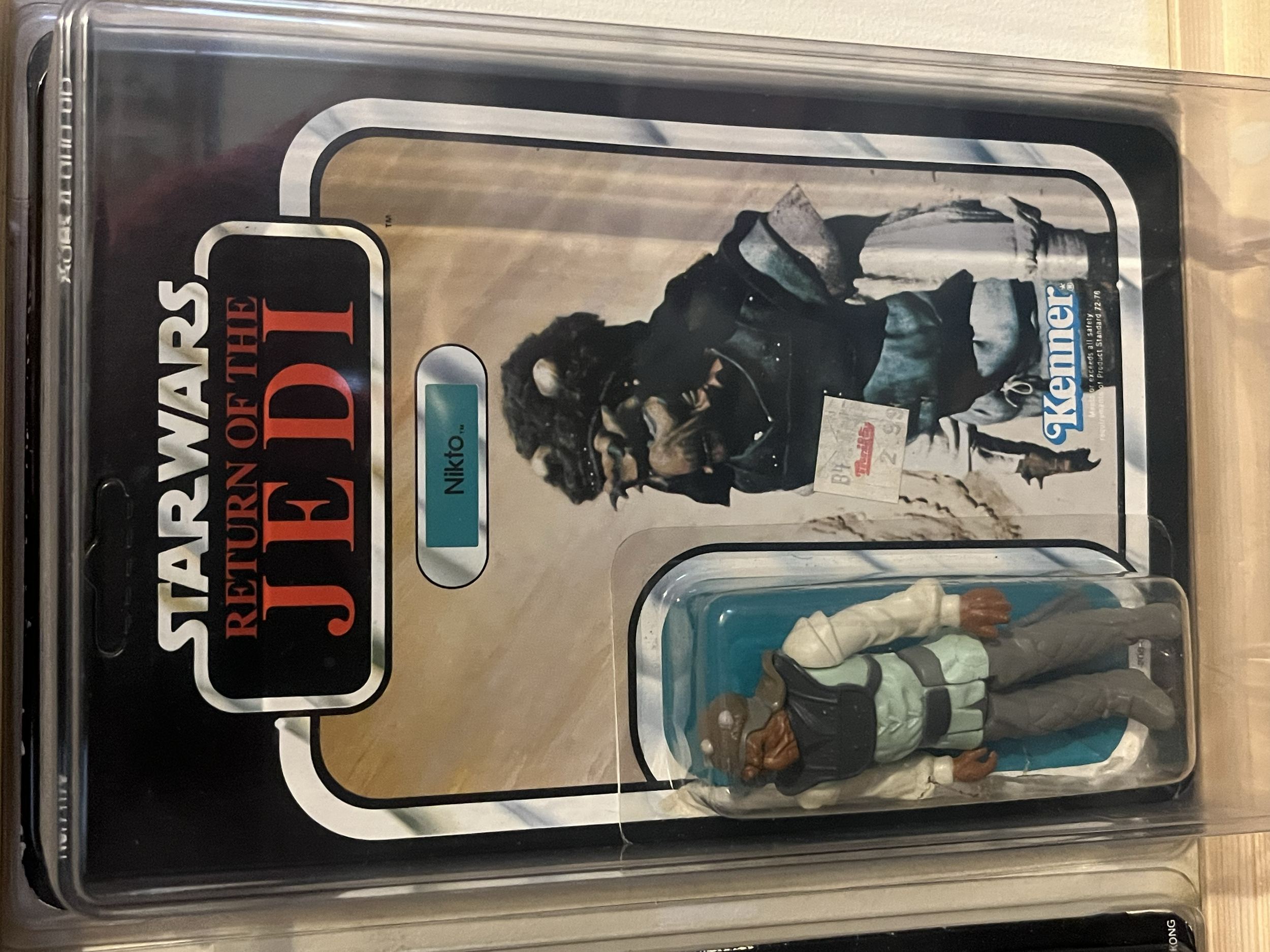 A collection of action figures including characters from Star Wars, Indiana Jones, and Marvel, stored in a clear plastic container.