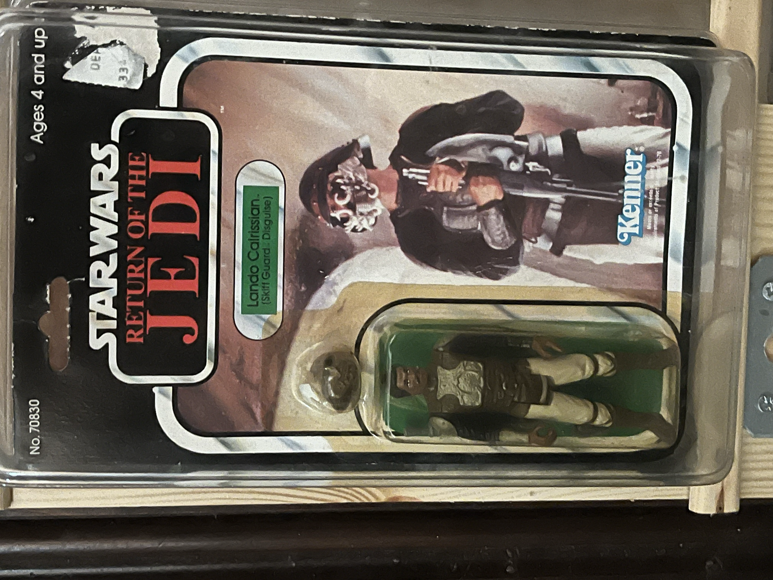 Packaging of a Jurassic World themed toy or collectible, featuring a character in ninja attire holding a sword, with a background scene from the Jurassic World franchise, including a dinosaur.