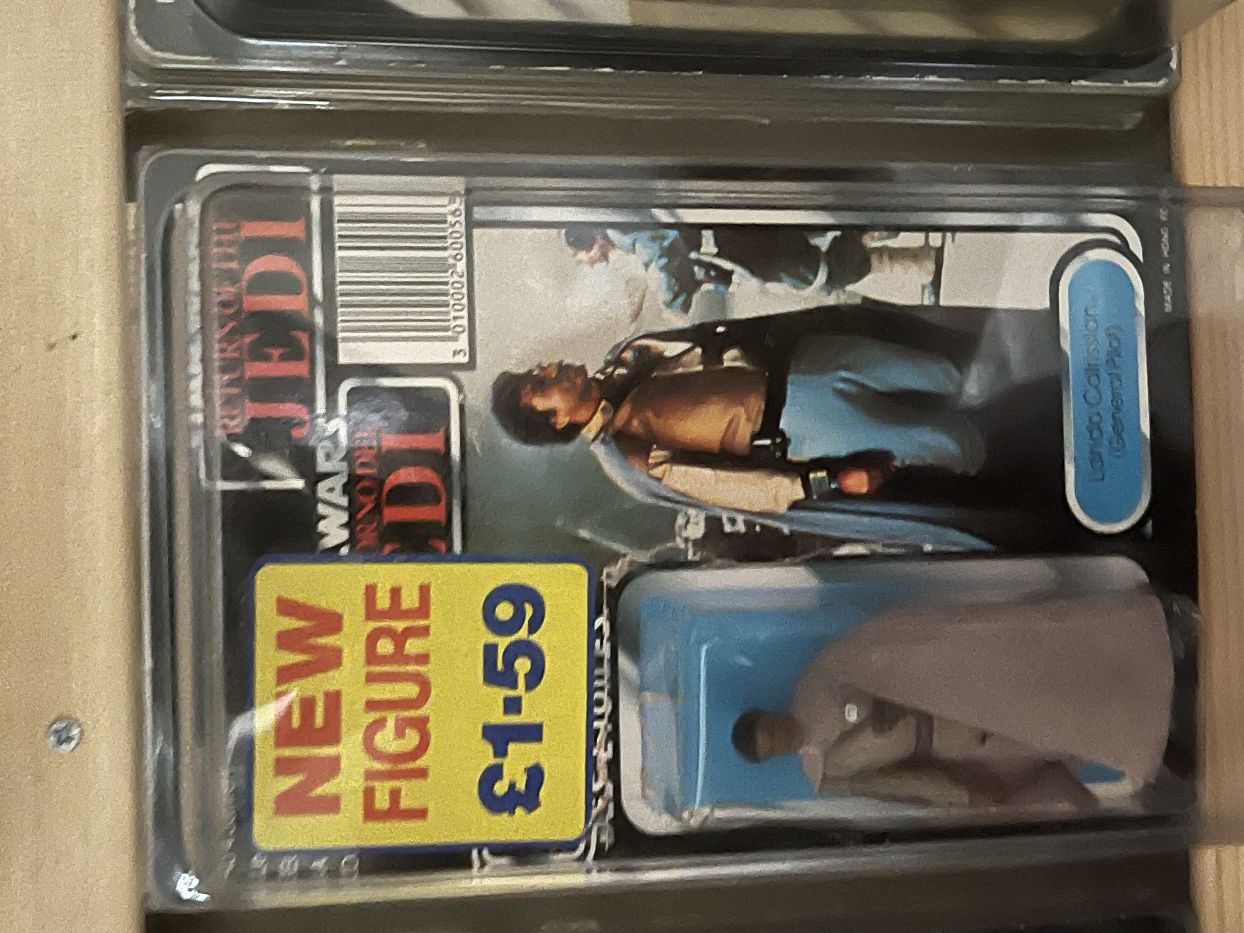 A pack of trading cards with a visible card featuring a woman with dark hair and a yellow shirt, a blue signature, and a price sticker of $3.