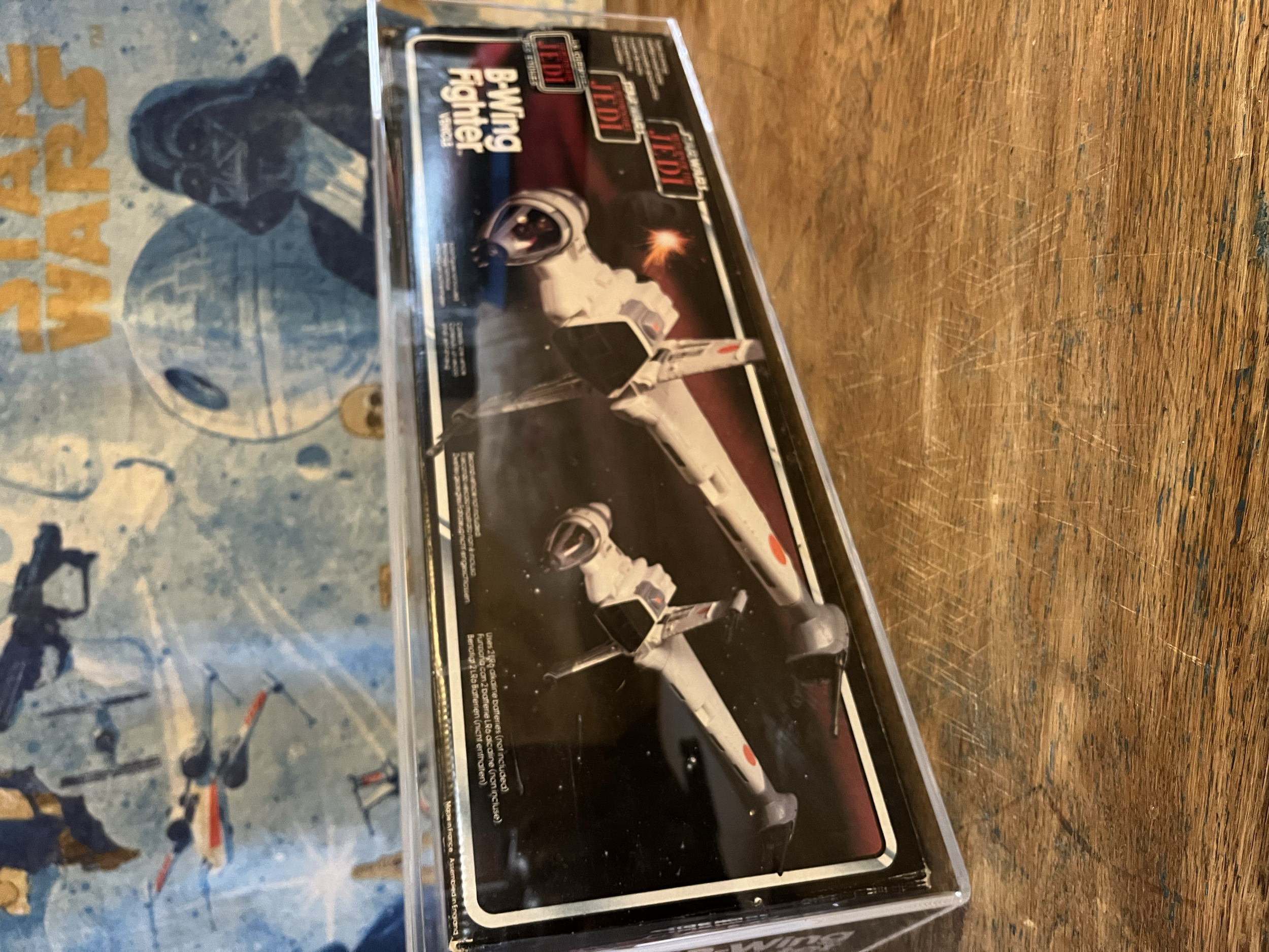 Star Wars Black Series Darth Vader figure in its packaging placed on a wooden surface.