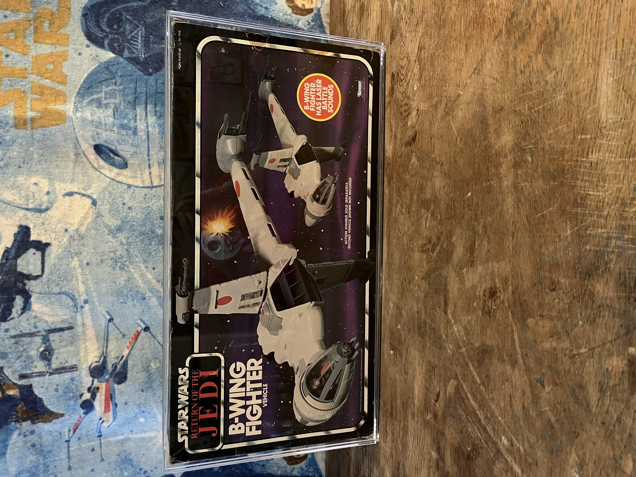 A science fiction toy set from Star Wars titled "Jedi Starfighters" featuring a model of a spaceship with a light-colored body and black and orange details, displayed in a clear plastic case.