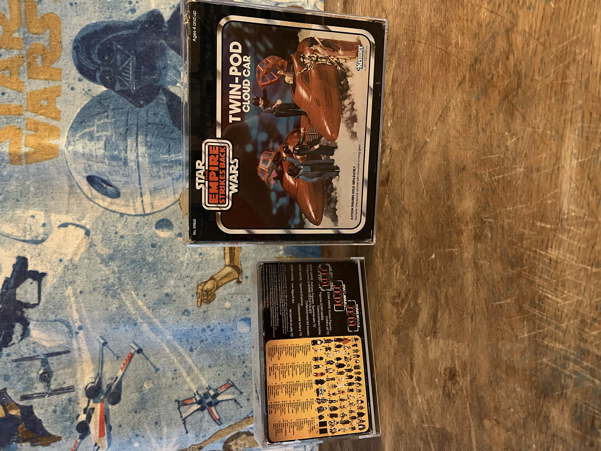 A Star Wars action figure set box featuring characters from Star Wars Episode I. The box displays a scene with a tan-colored aircraft and multiple characters in various poses, set against a black background with the Star Wars logo at the bottom.