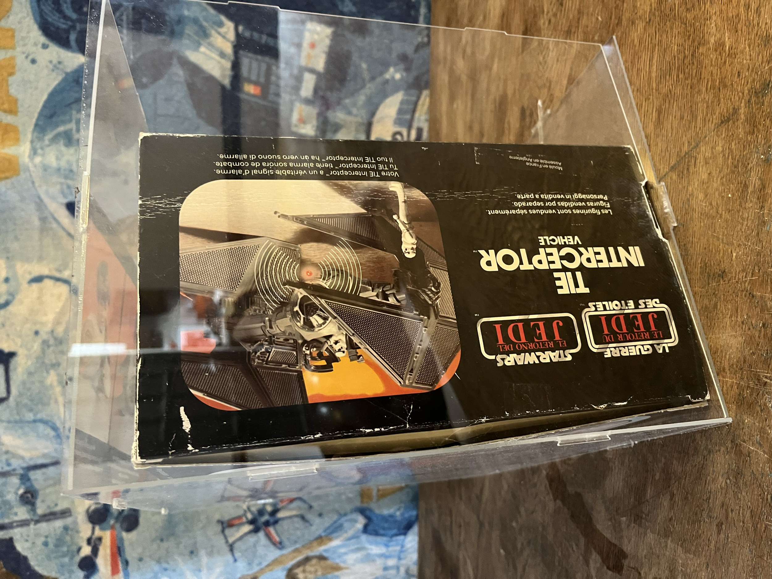 A boxed set of stereo speakers with images of speakers and a loudspeaker on the box, placed on a wooden surface.