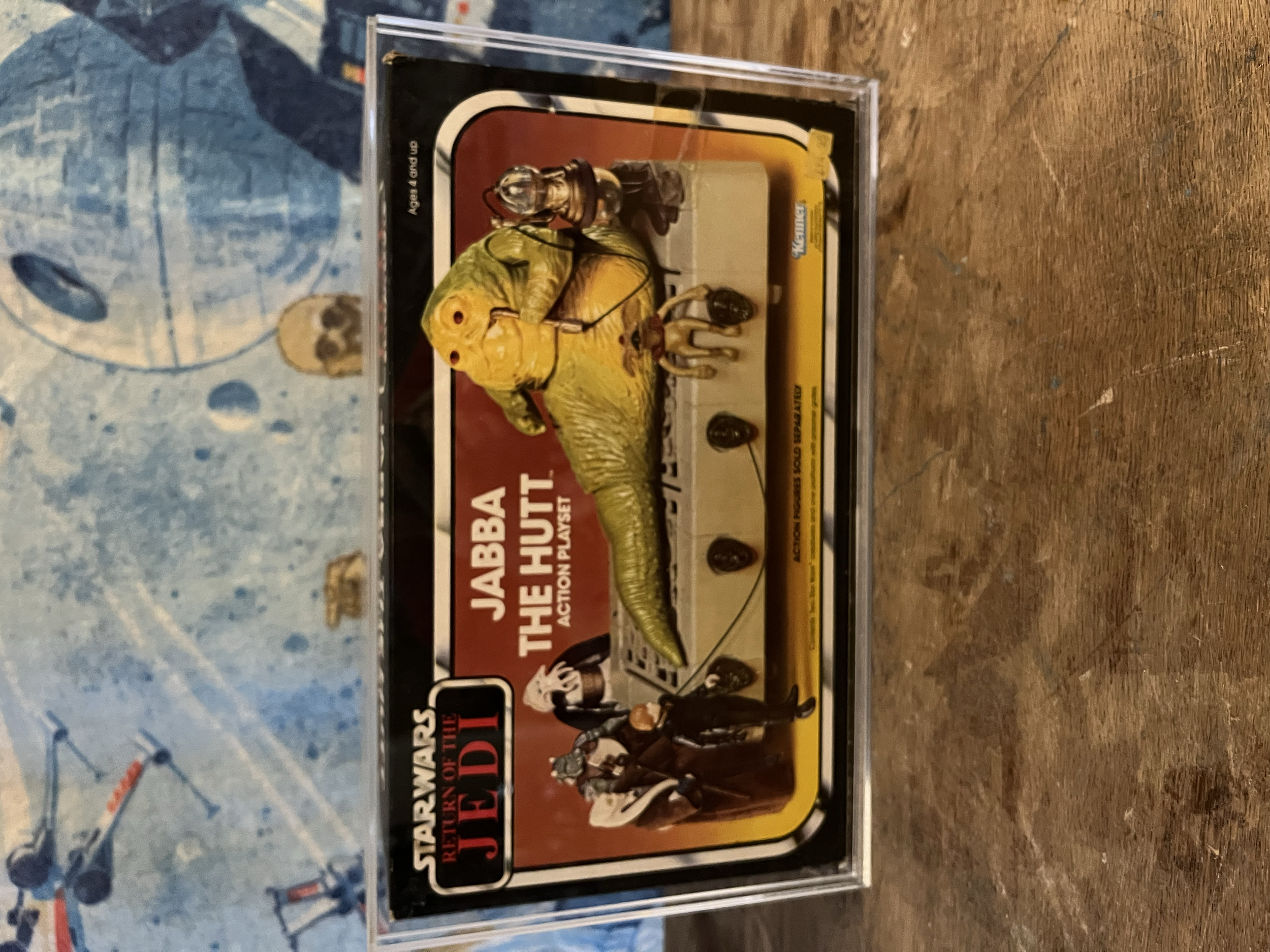 The image shows a boxed Jabba the hut action figure set from 'Star Wars: Return of the Jedi', featuring characters including Darth Vader, a stormtrooper, and other figures from the Star Wars universe.