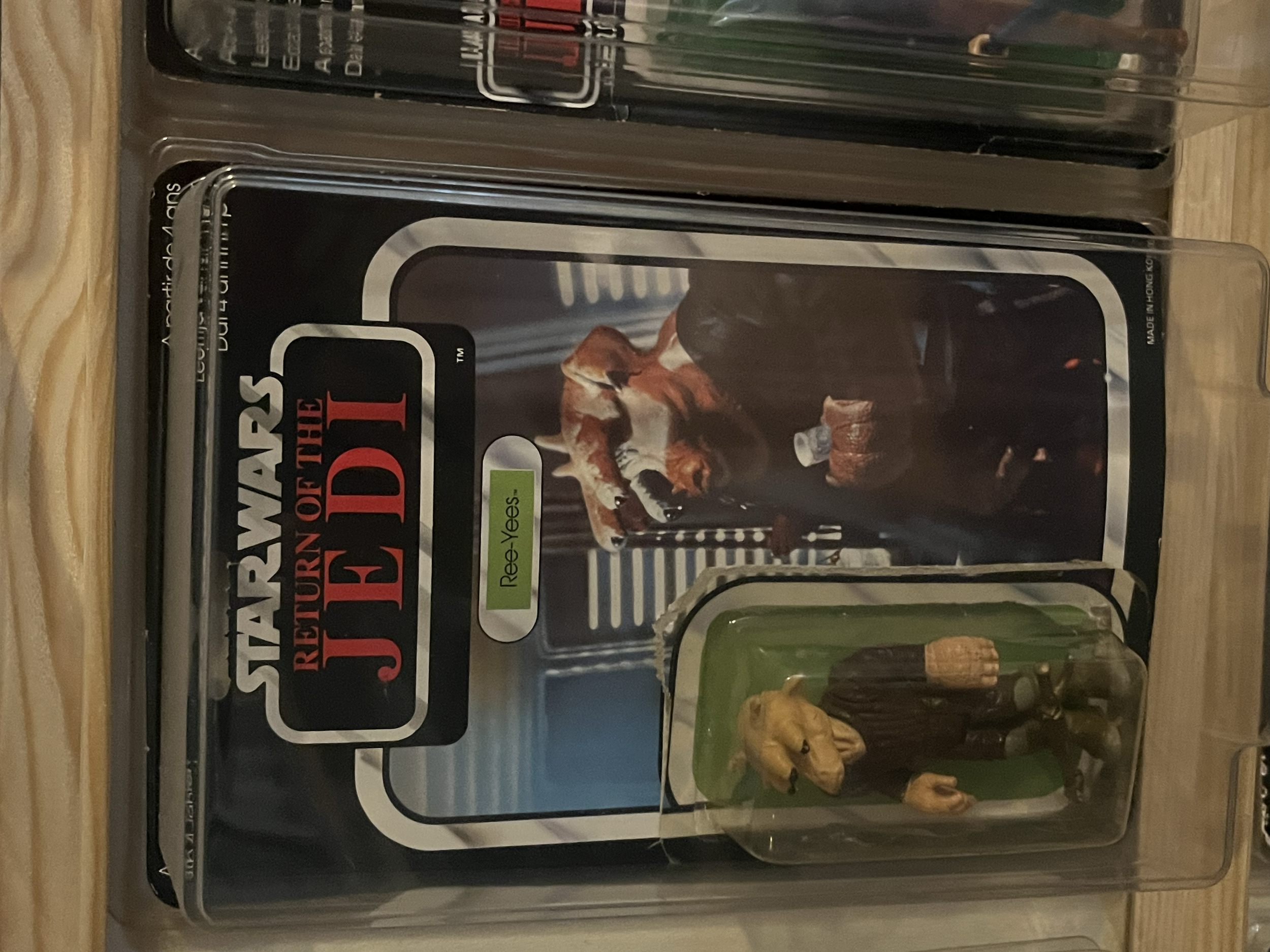 A storage container filled with various action figures and collectibles from the 'Star Wars' universe, including figures of Anakin Skywalker and other characters, with a 'Star Wars: The Empire Strikes Back' label.