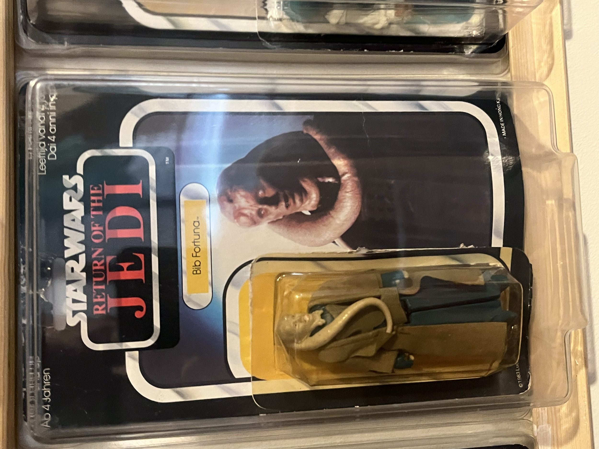 Close-up of a packaged DVD titled 'Star Wars: The Empire Strikes Back' with a picture of a woman in a black dress on the cover. The DVD case is in plastic wrapping, and part of a brass-colored object is visible at the bottom of the image.