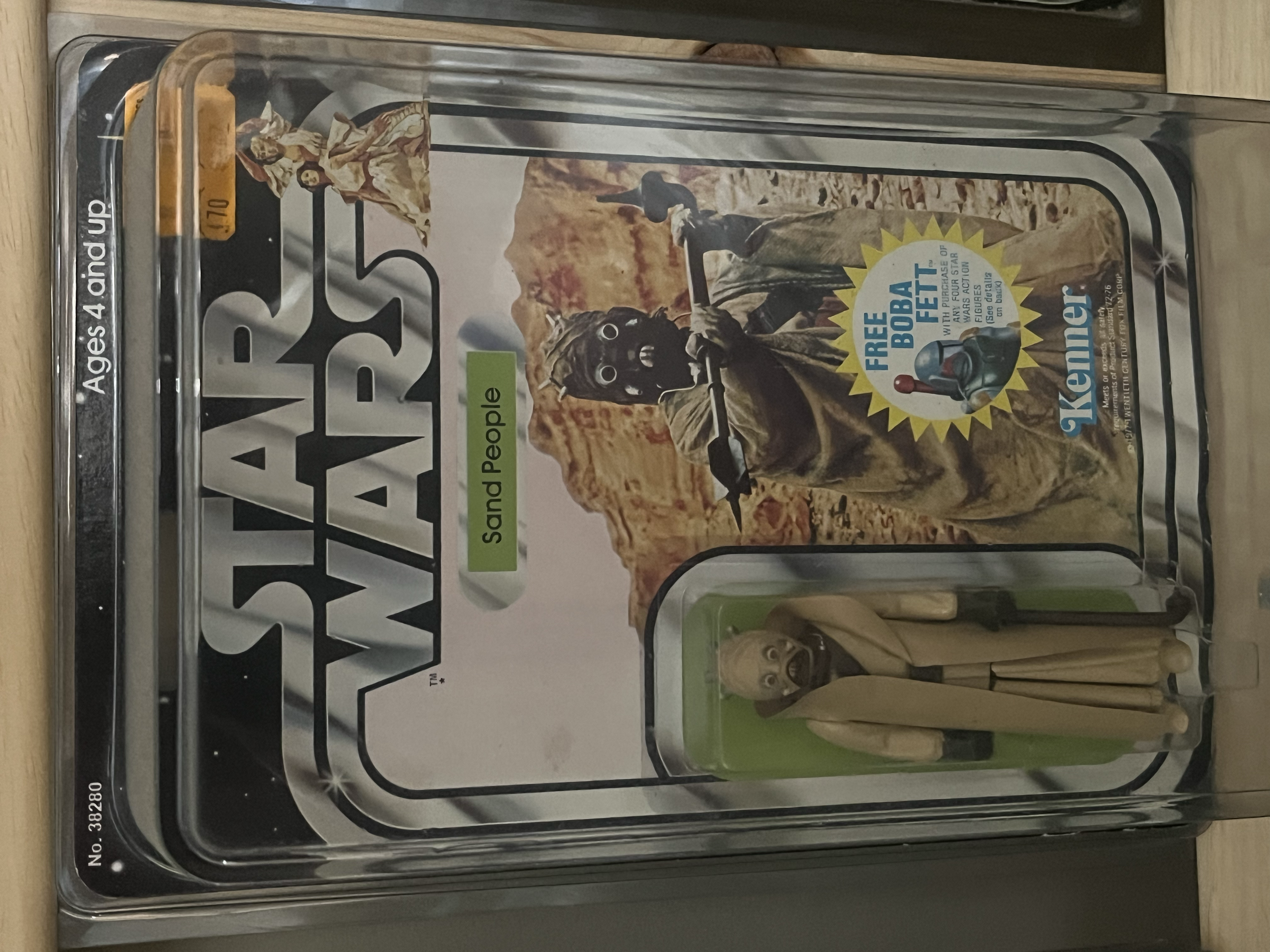 A vintage Tin Robot with a suction cup base and beige color, packaged in a plastic container with a colorful cardboard backing.