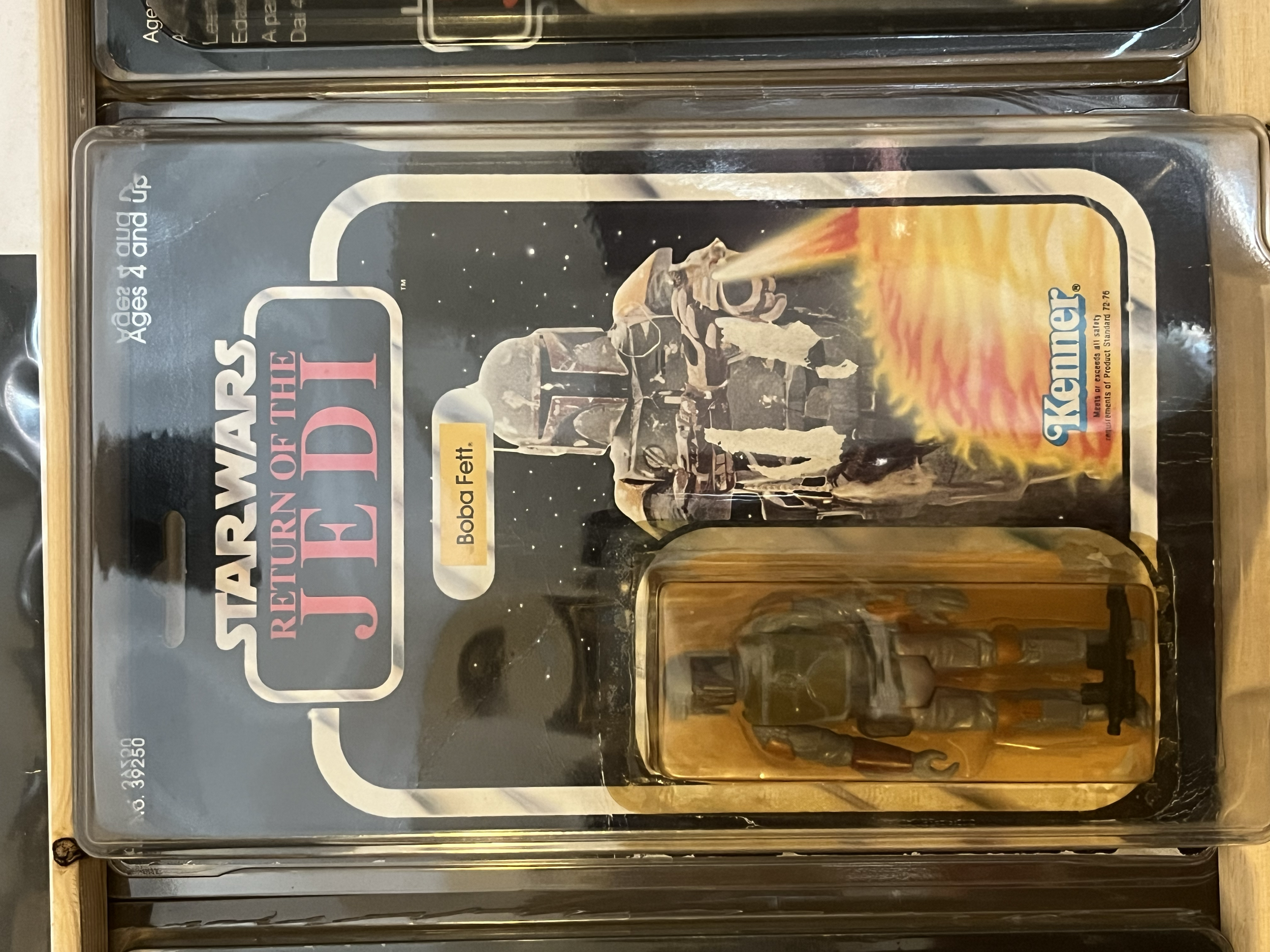 A set of vintage Star Wars action figures in sealed packaging, featuring characters such as Han Solo from the Star Wars universe. The figures are displayed in clear plastic cases with a starry space background, and the packaging has branding and age 