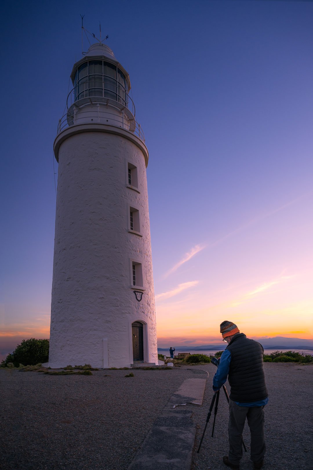 A photographer capturing sunset on Bruny Island lighthouse