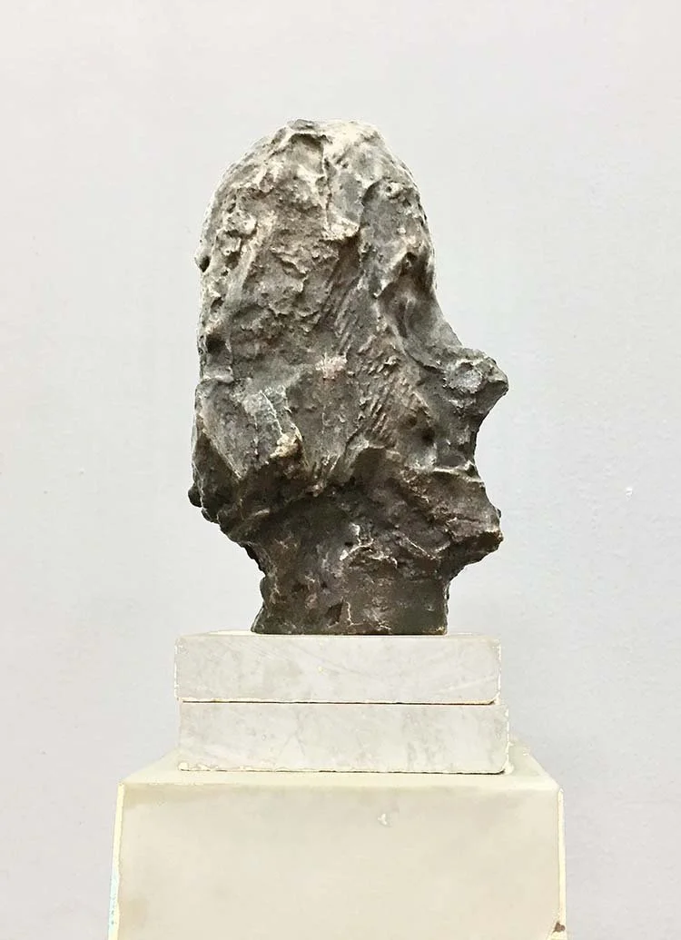 Close-up of an abstract, rough sculpture of a human head's profile, bronze, 25 cm, 2014