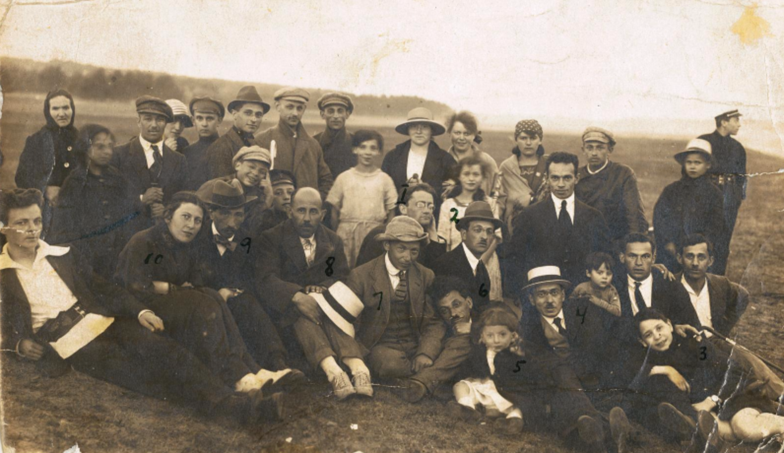 Dovid Bergelson (6, on ground with his head on his neighbour’s knee), his wife Zipora (10, seated, second from left), and only son - Prof. Lev Bergelson (5, small child to Bergelson’s left) among a group of friends and colleagues.