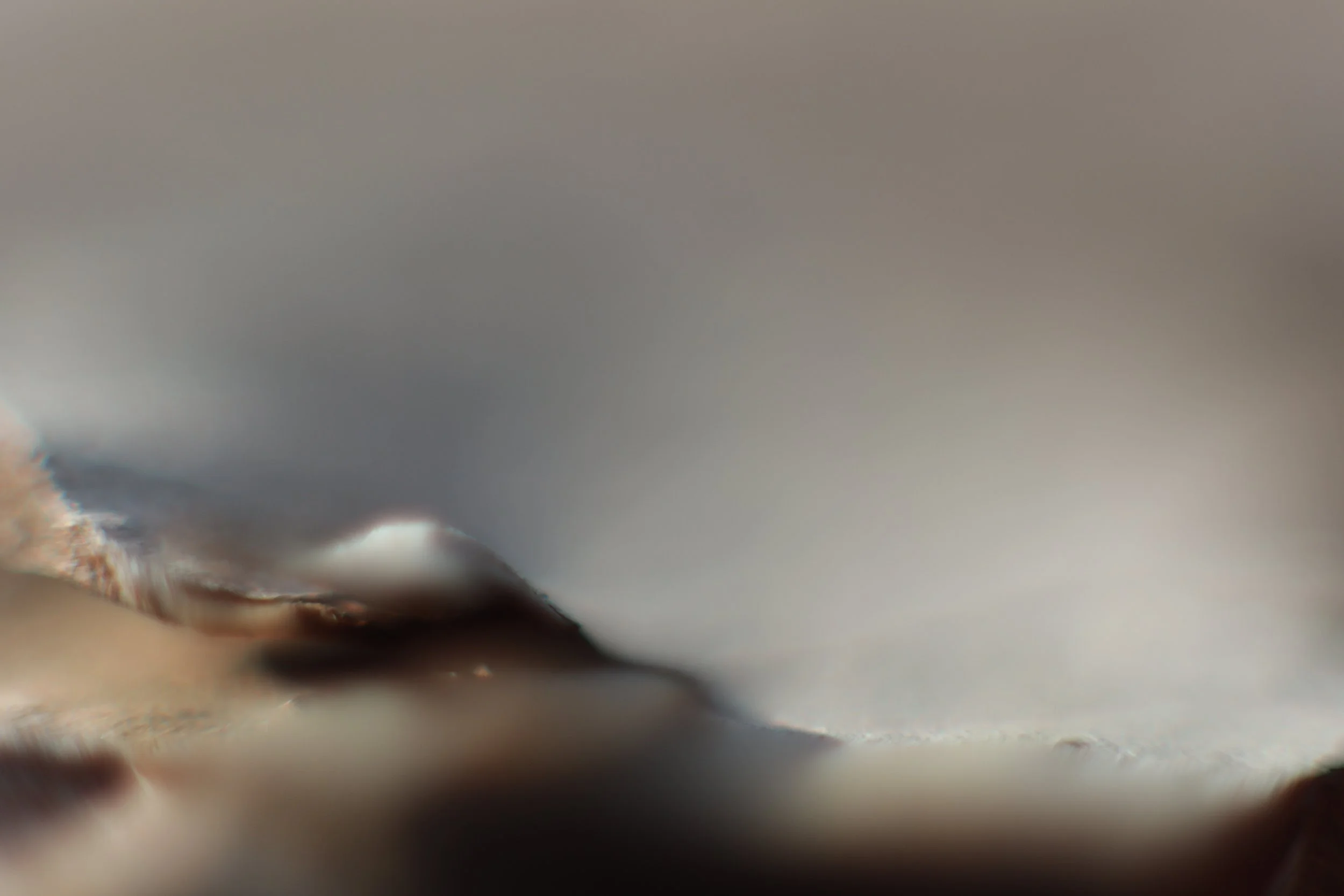 Un sommet neigeux flottant au dessus l'atmosphère. La zone de netteté très réduite met en exergue un bokeh très doux.