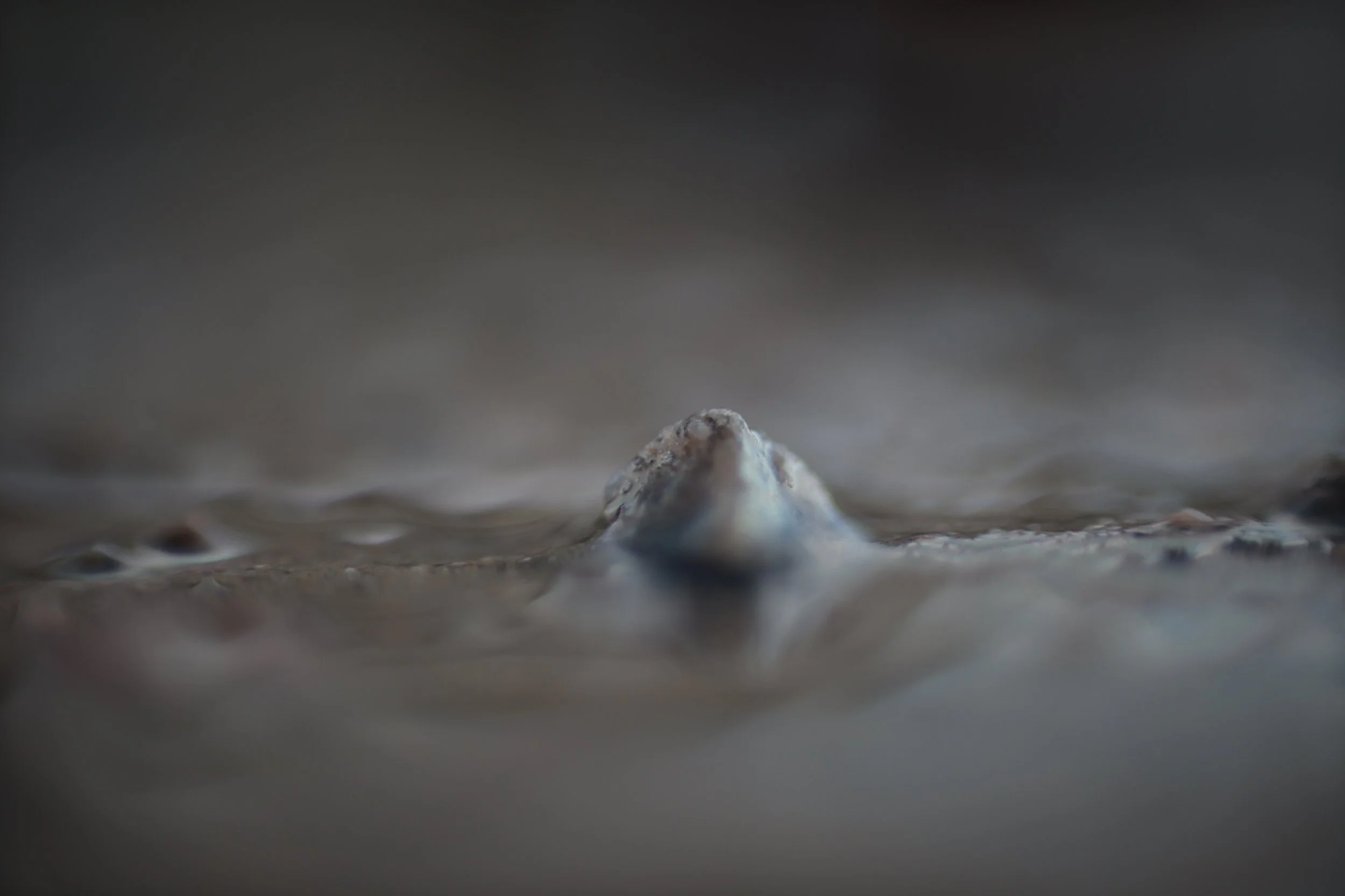 Rocher d'une texture surnaturelle émergeant d'un liquide épais