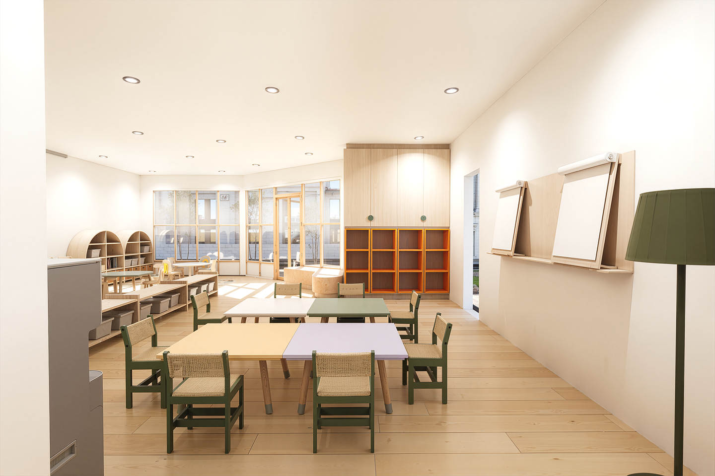 Bright, minimalist classroom with wooden furniture, tables, green chairs, and large windows letting in natural light