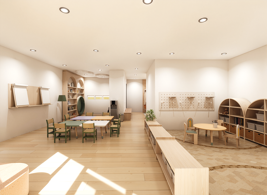 Bright classroom with wooden floors, white walls, and ceiling lights. Contains small tables and chairs, shelves with toys and books, and play areas for children.