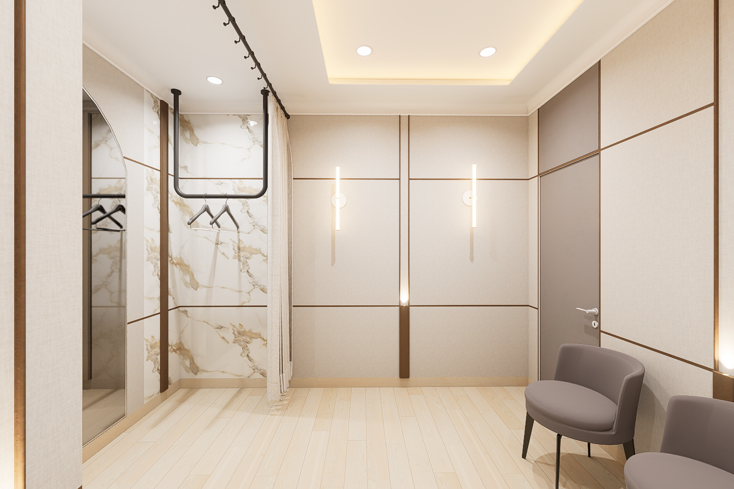 Modern interior room with beige and gray walls, light wood flooring, a ceiling light, and wall sconces. There are two gray chairs on the right side and a closet with a curtain and hangers on the left.