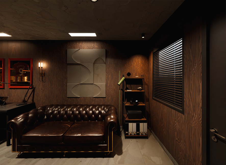 A cozy office corner with a dark brown leather tufted sofa, wall-mounted art, wooden shelving with decorative items, a window with blinds, and warm ambient lighting.