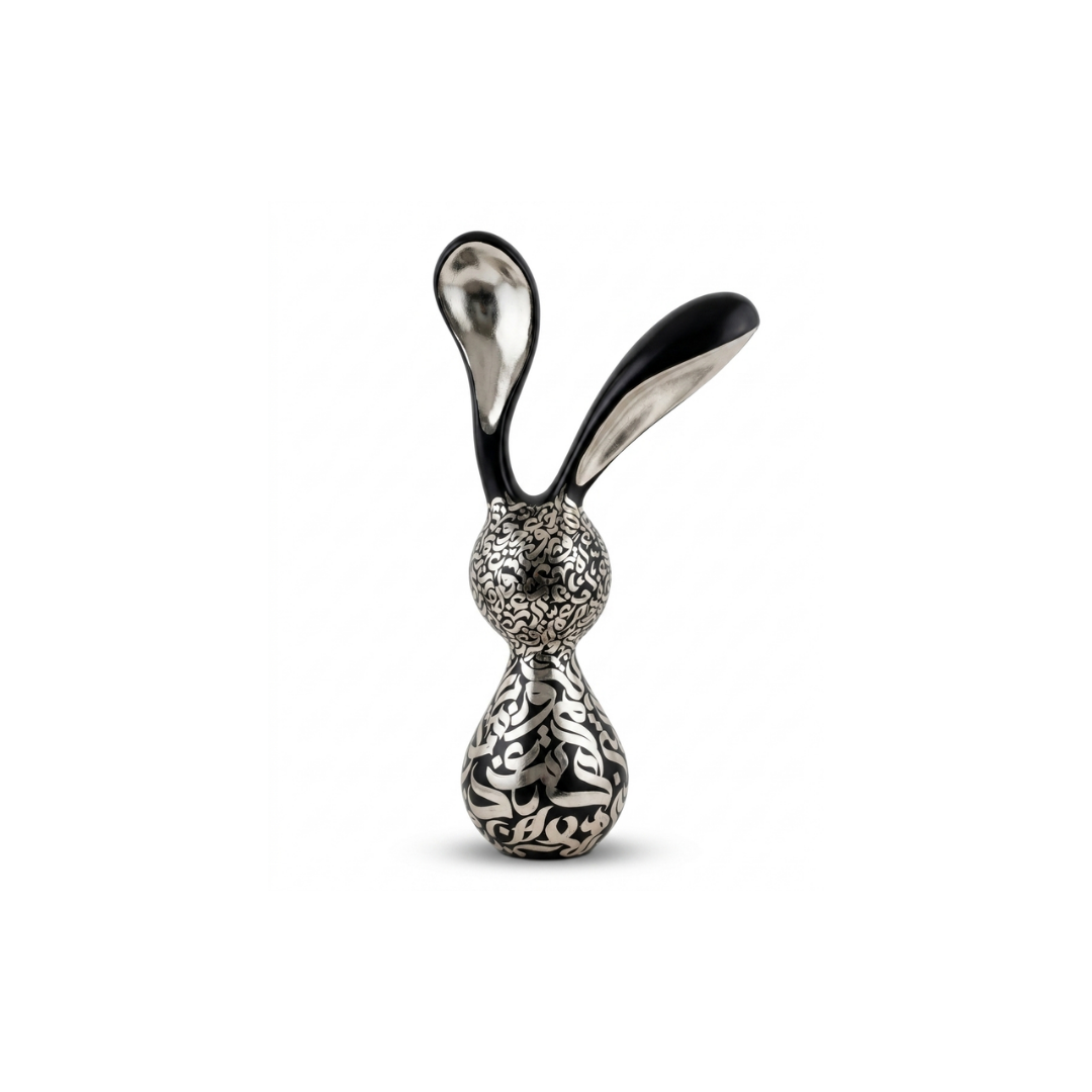 An abstract black, white, and silver sculpture resembling a rabbit with long, curved ears named “Nouran,” by Shirin Roshanaie, white background. ShisArt Studio