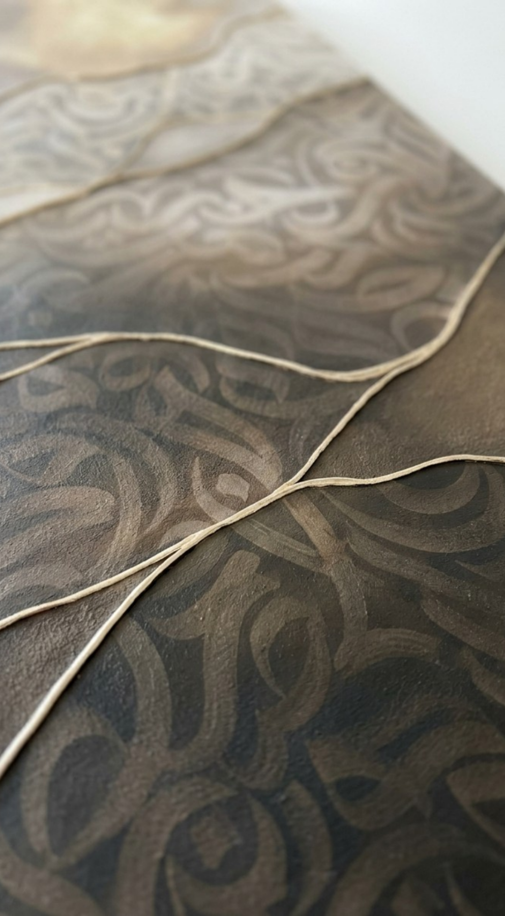 Close-up of “Lightborne,” an original mixed-media artwork by Shirin Roshanaie in shades of brown, beige, champagne, and champagne gold, featuring layered textures , wavy horizontal bands with intricate, and Persian and Arabic calligraphic forms. 