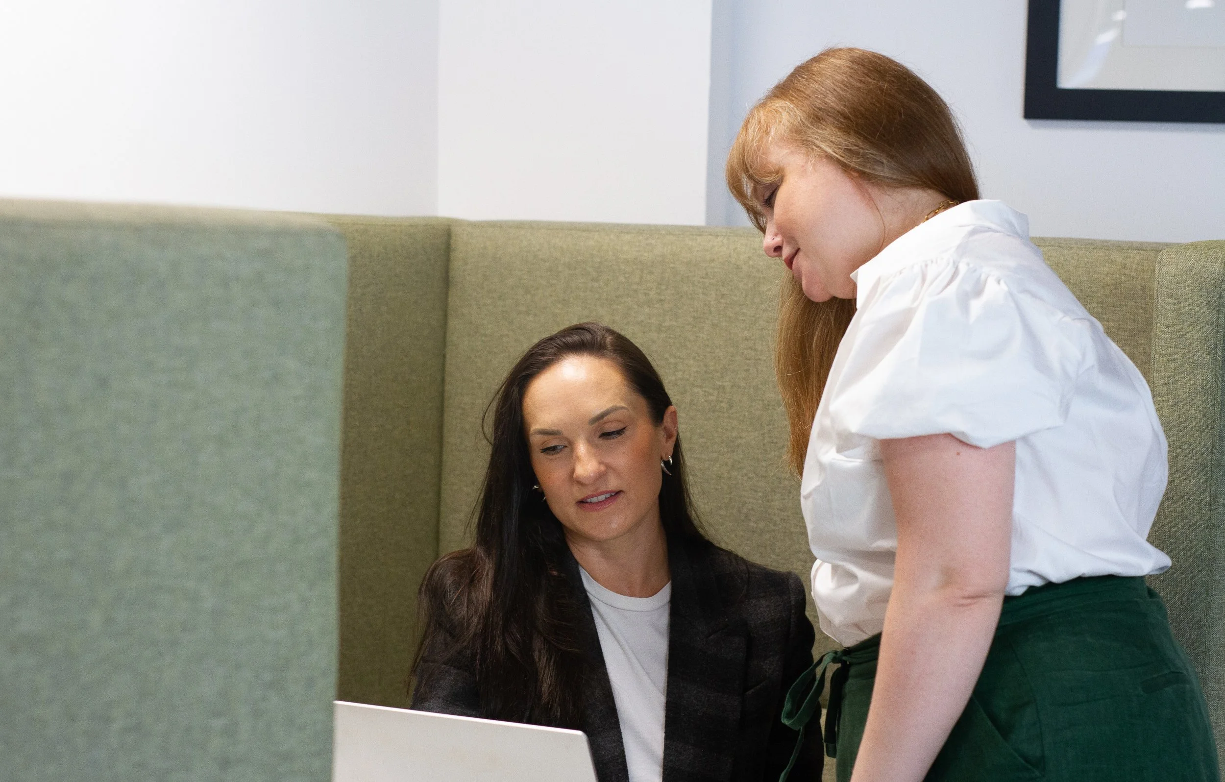 Sharon and Julianna from Olive Searhc discuss executive search in a meeting booth