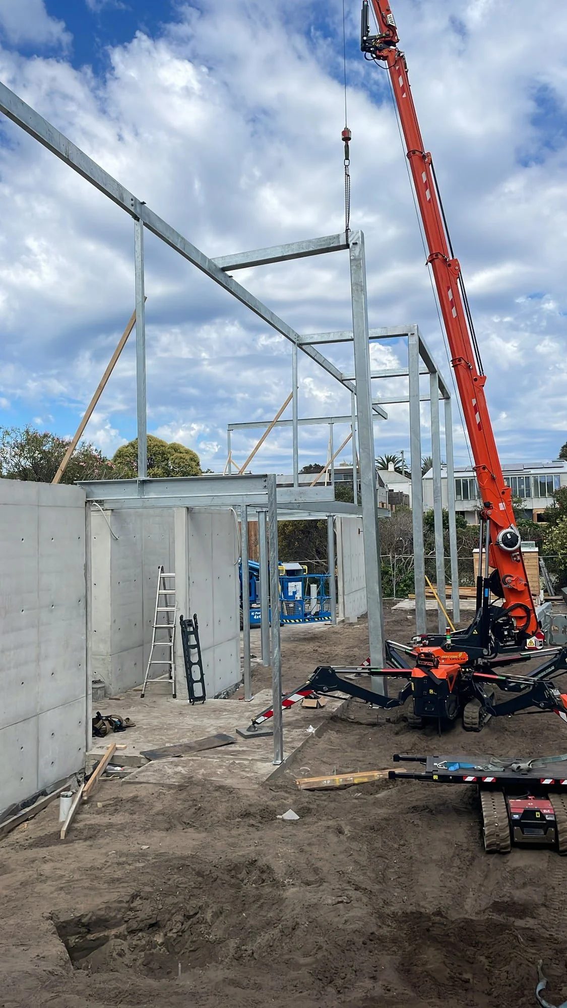 Spider crane lifting structural steel on a restricted Melbourne building site