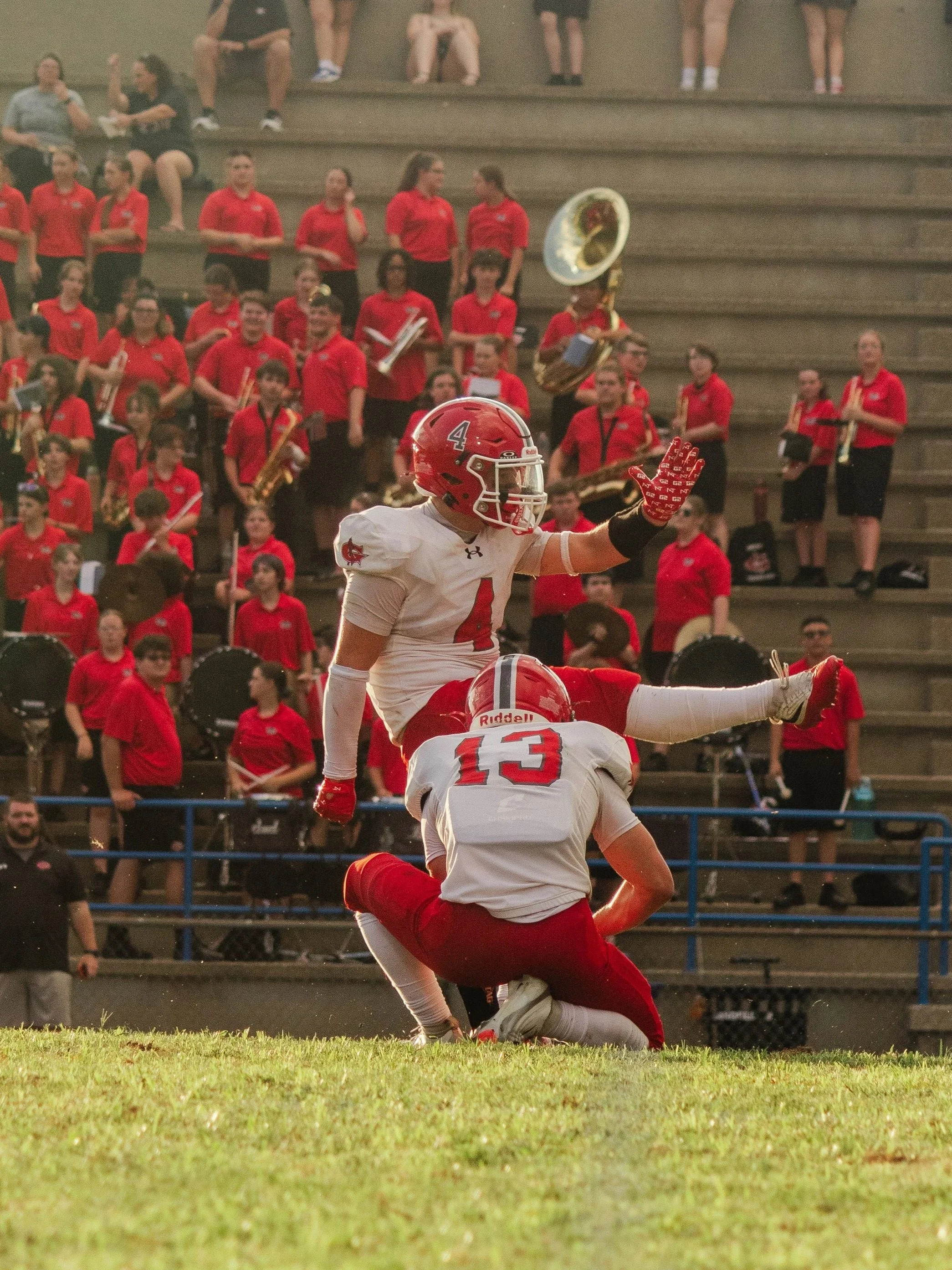 American football players celebrating on field during game, with spectators watching from bleachers in background.