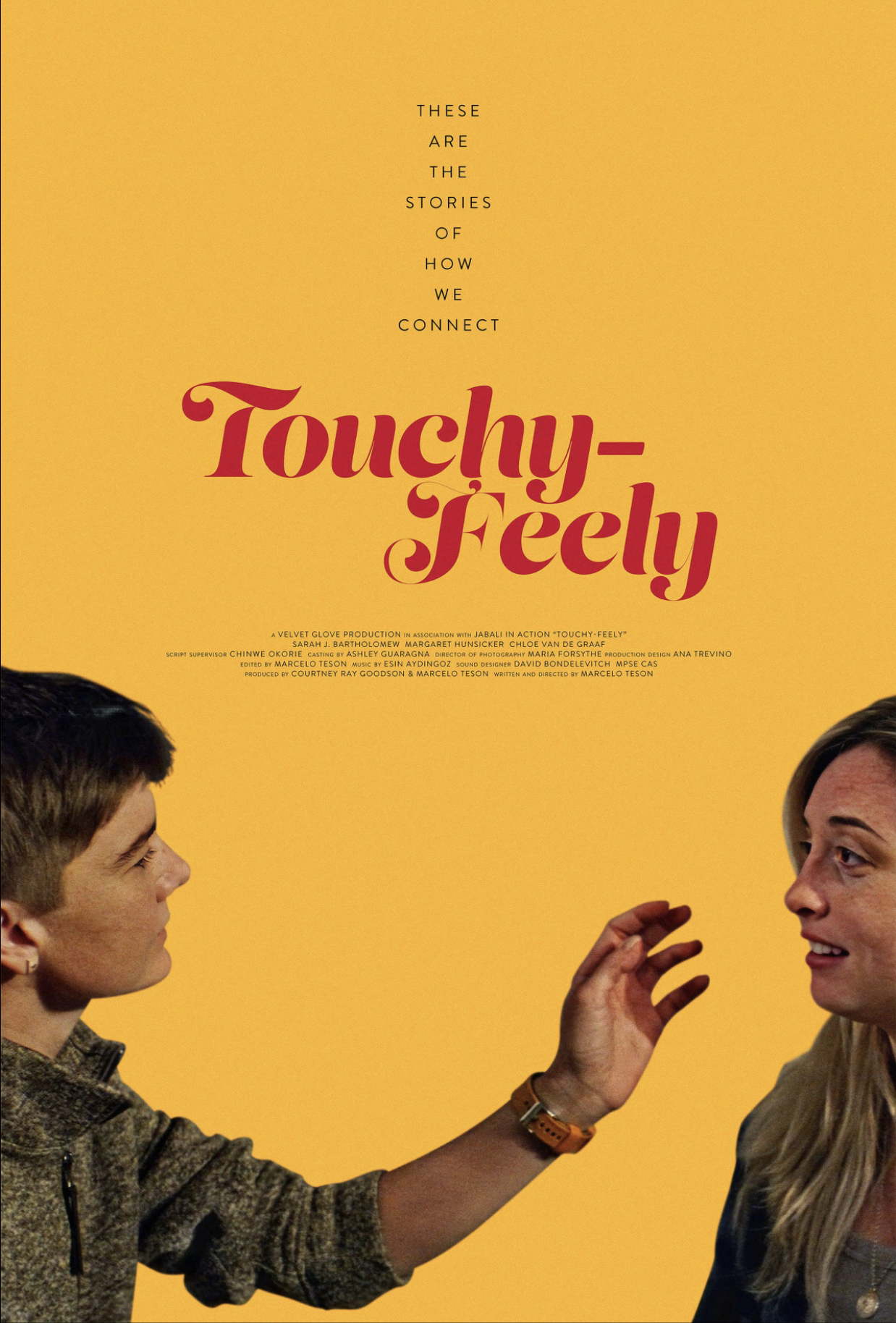 Poster with yellow background featuring a man and a woman engaging in an expressive conversation, with the title 'Touchy-Feely' in red cursive style text and a subtitle about stories of connection.