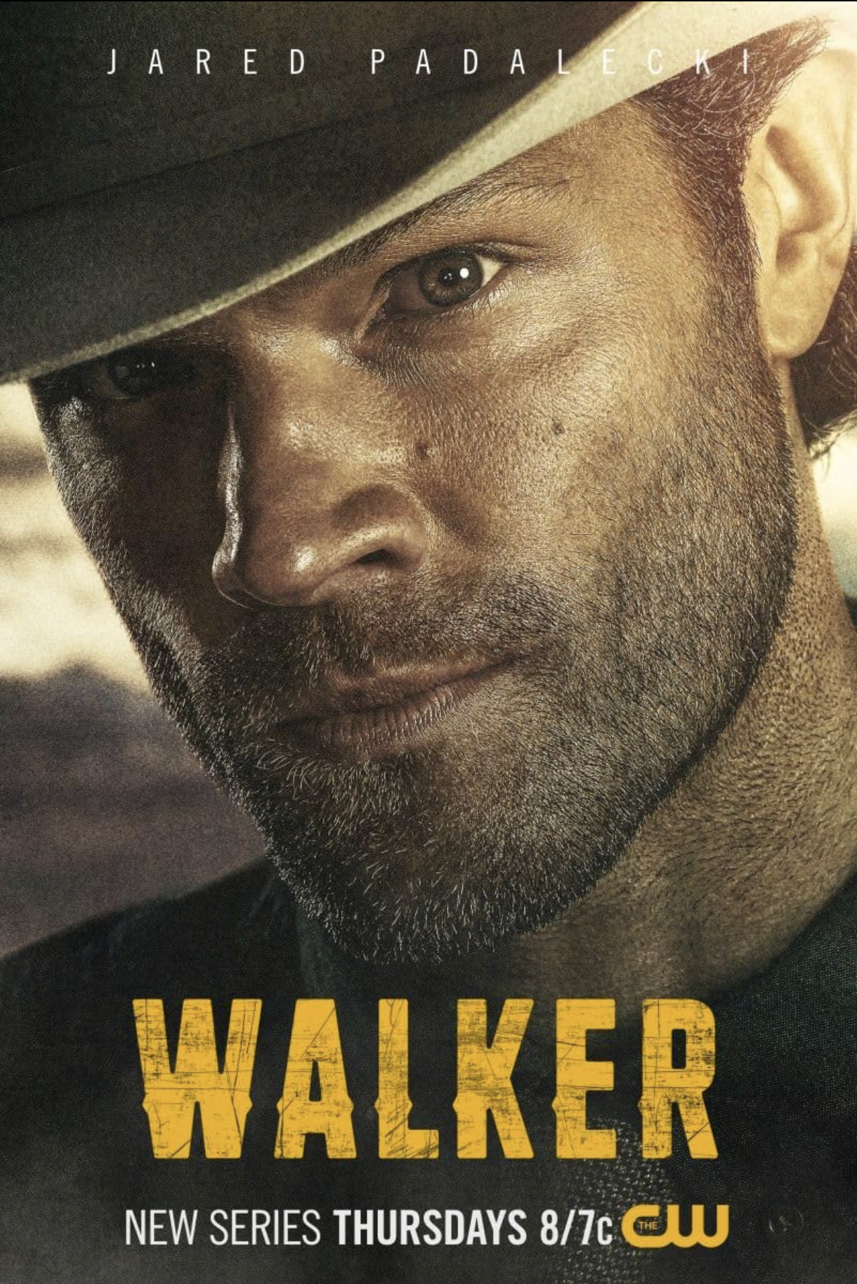 Close-up of a man with a beard and mustache wearing a dark hat, looking directly. The text on the image promotes a new TV series called "Walker" premiering Thursdays at 8/7c on The CW.