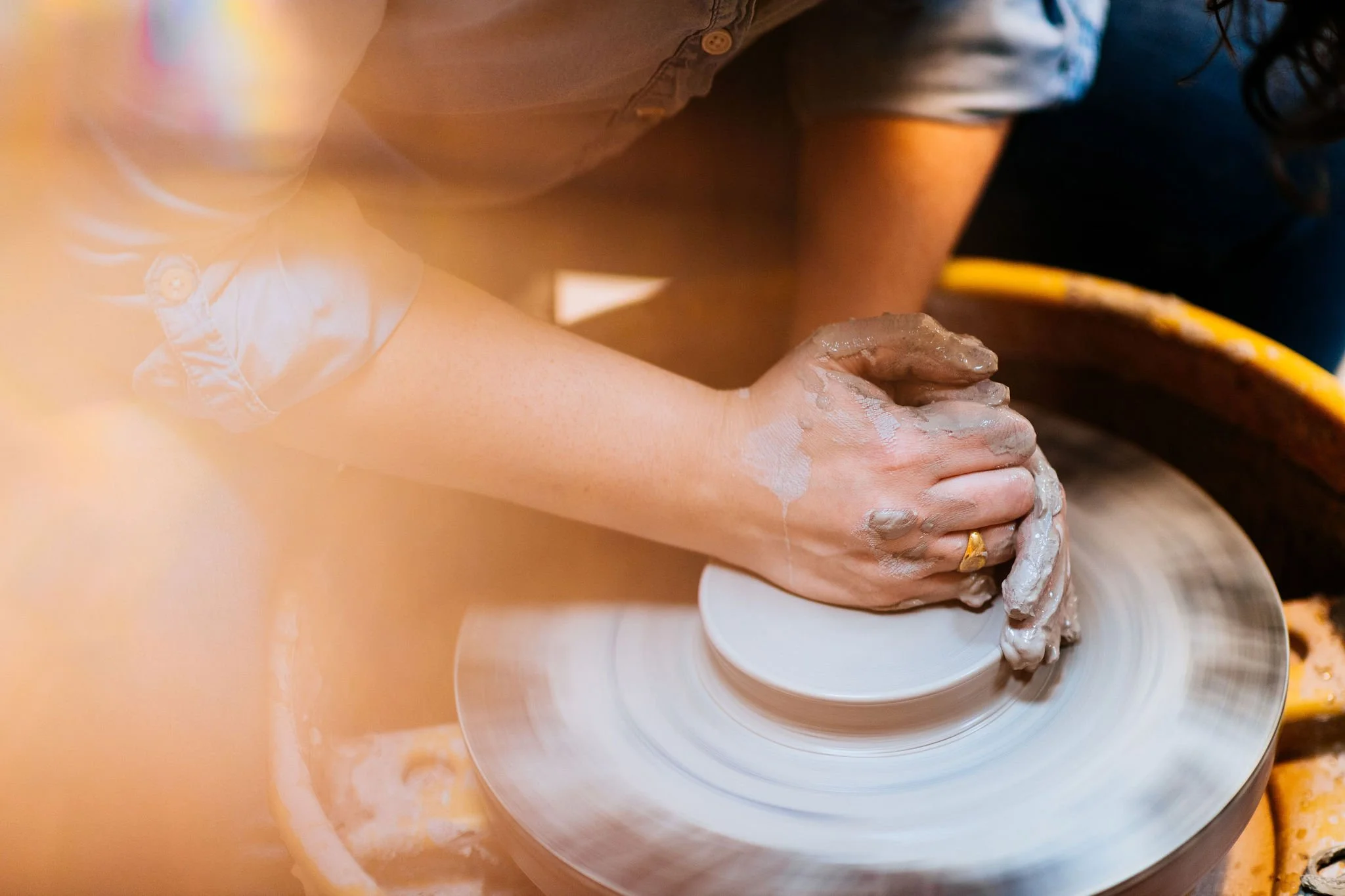 photo of meghann's hands on clay at her pottery wheel
