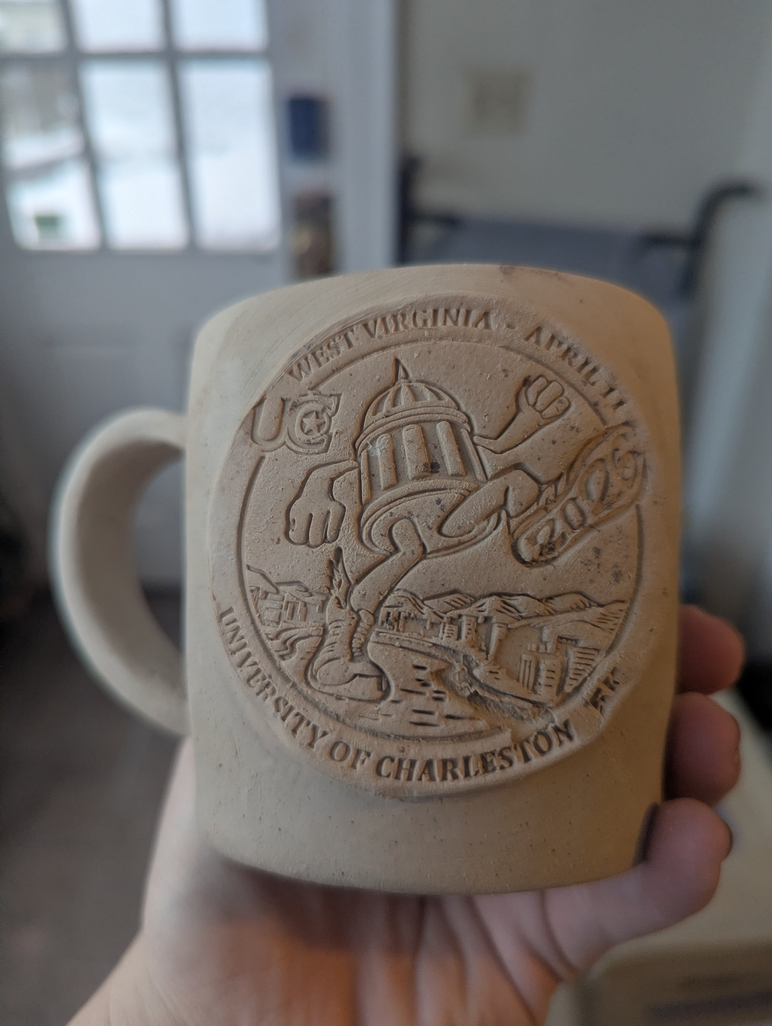 picture of a mug with UC Marathon logo stamped in it