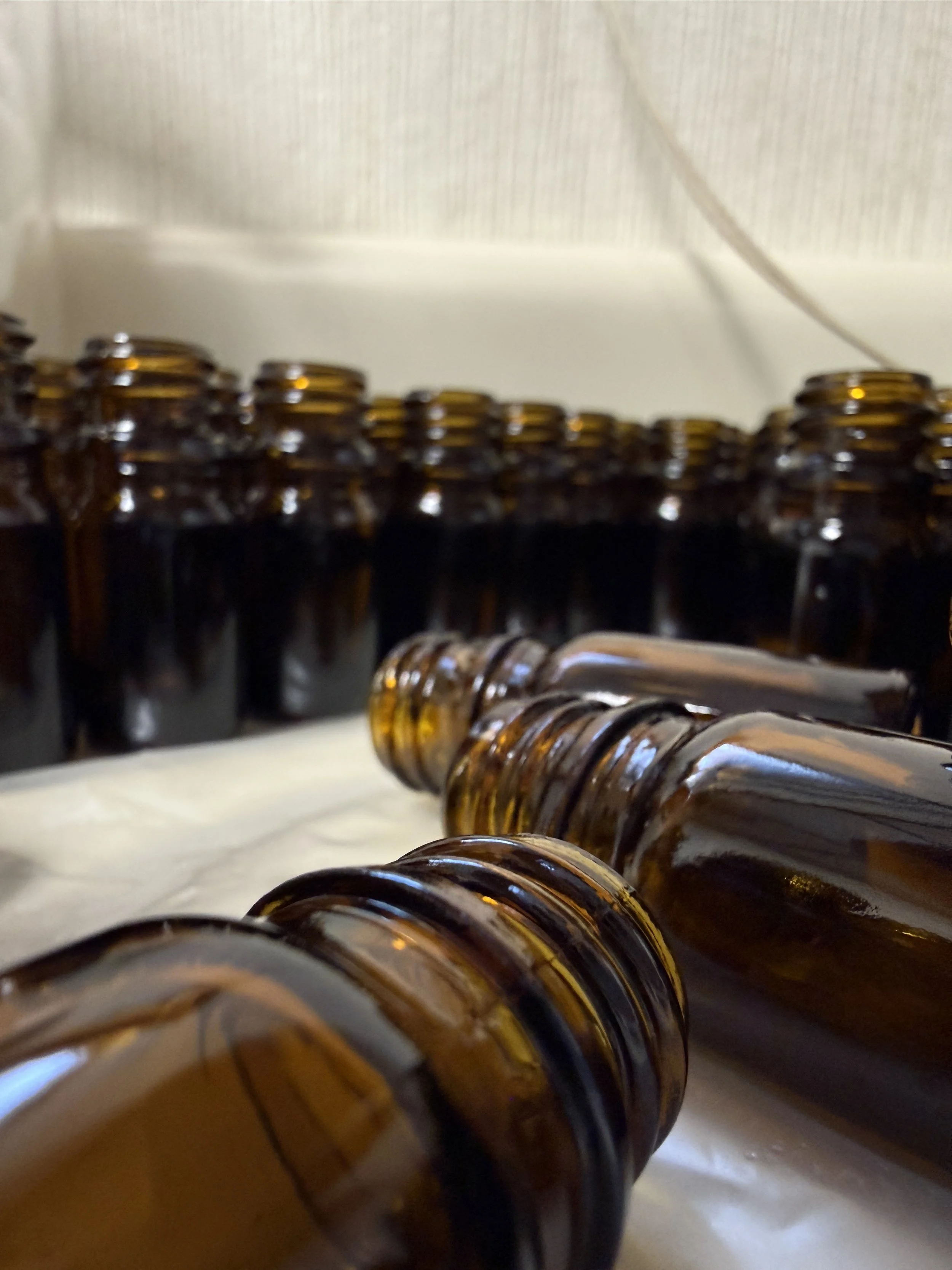 A collection of empty brown glass bottles arranged on a shelf or counter.